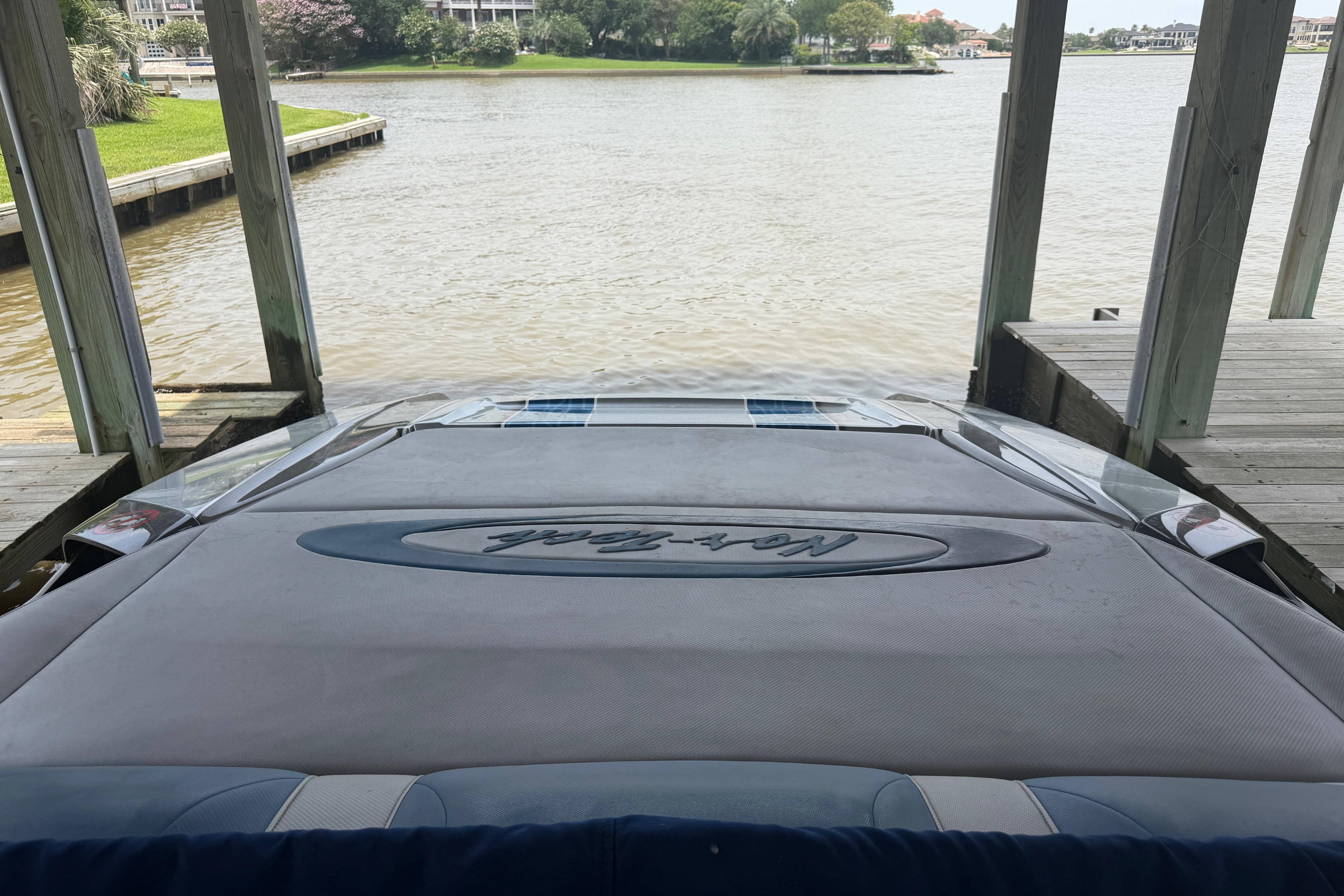 2013 Nor-Tech 477 SPX Vee Bottom boat docked by a serene waterfront.