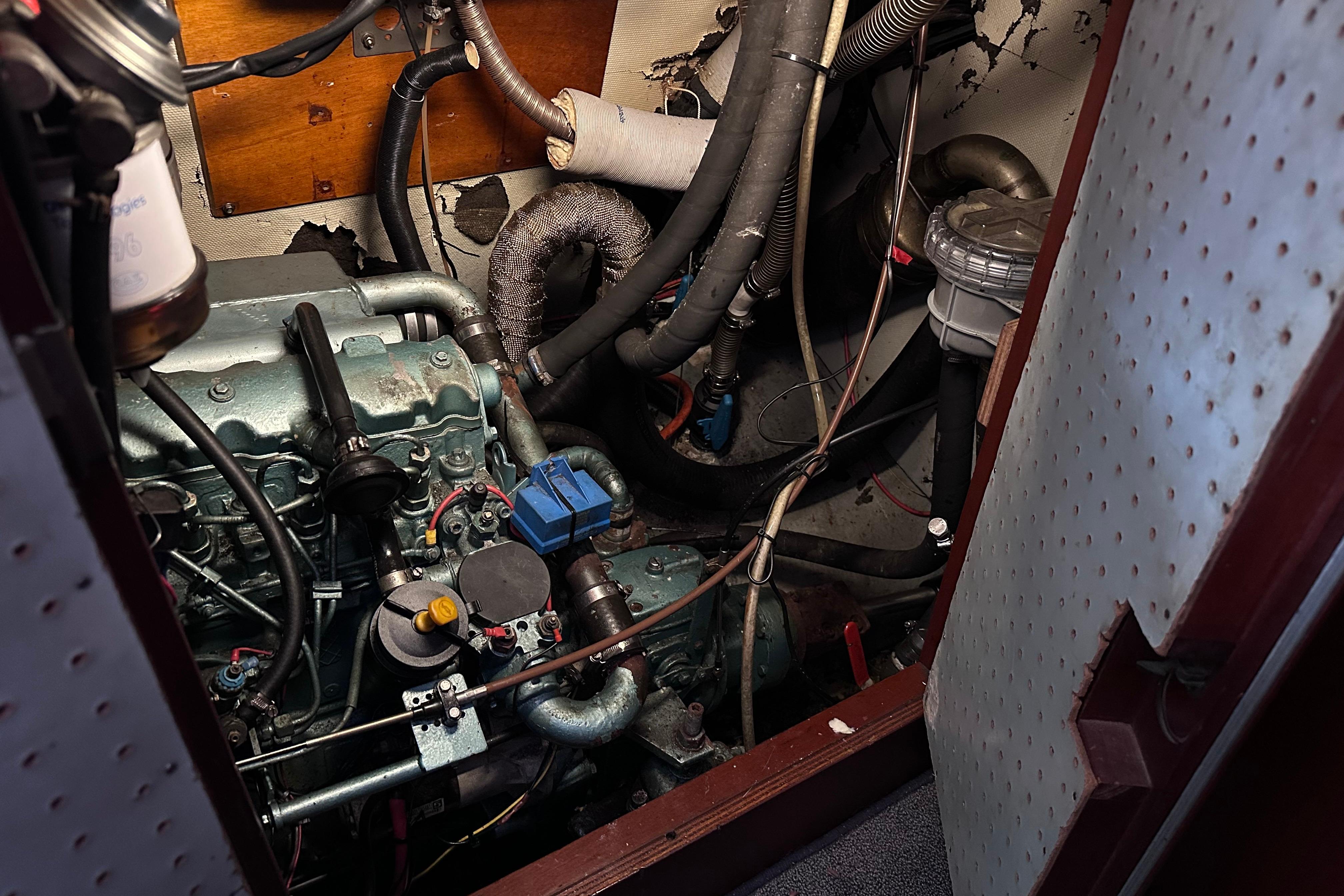 Engine compartment of a 1980 Hallberg-Rassy 352 sailboat, showcasing mechanical components and wiring.