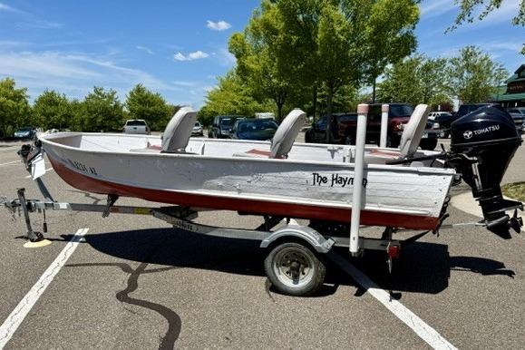 1958 Jon Boat Aluminum model on trailer, parked in sunny lot with trees.