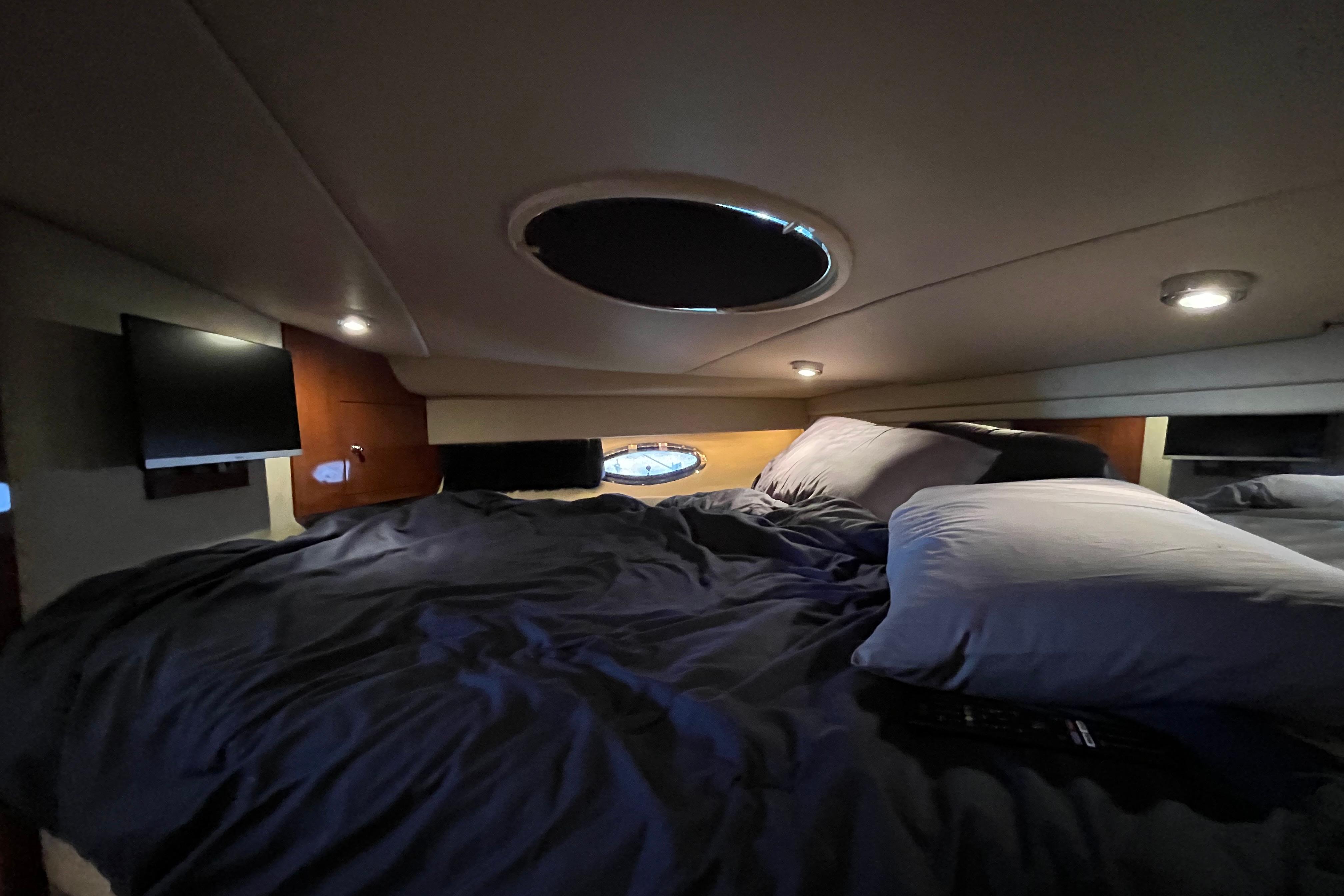 Cozy cabin interior of 2007 Regal 3760 IB Commodore yacht with bed and ambient lighting.
