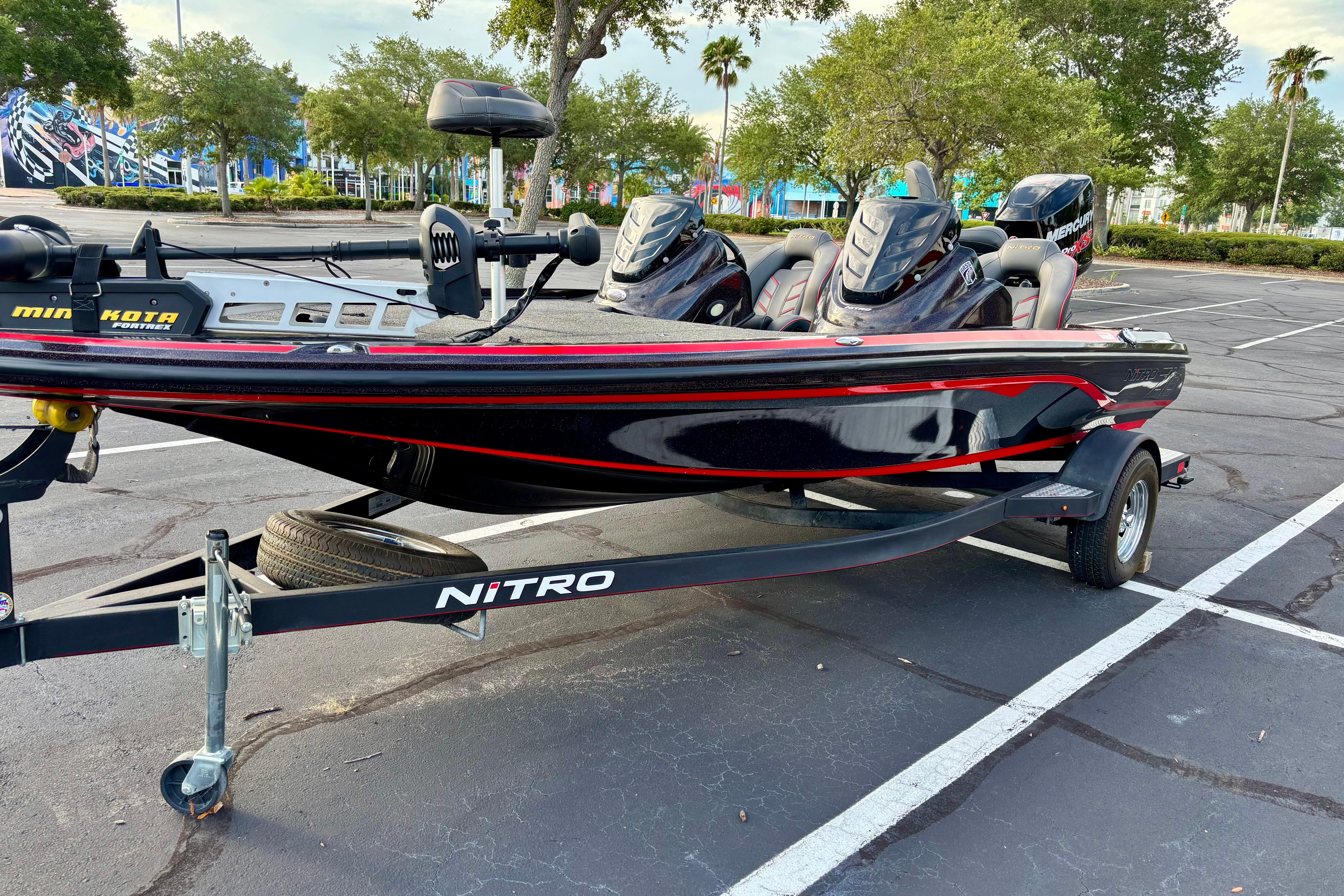 2018 Nitro Z18 boat on trailer in parking lot, featuring sleek black and red design.