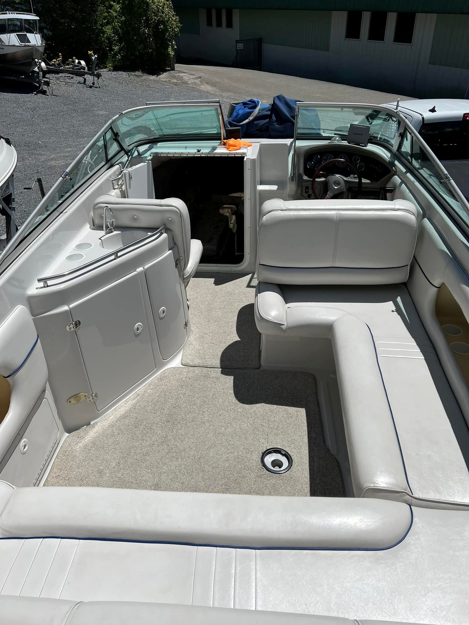 Interior of a 1999 Crownline 266 CCR boat with white seating.