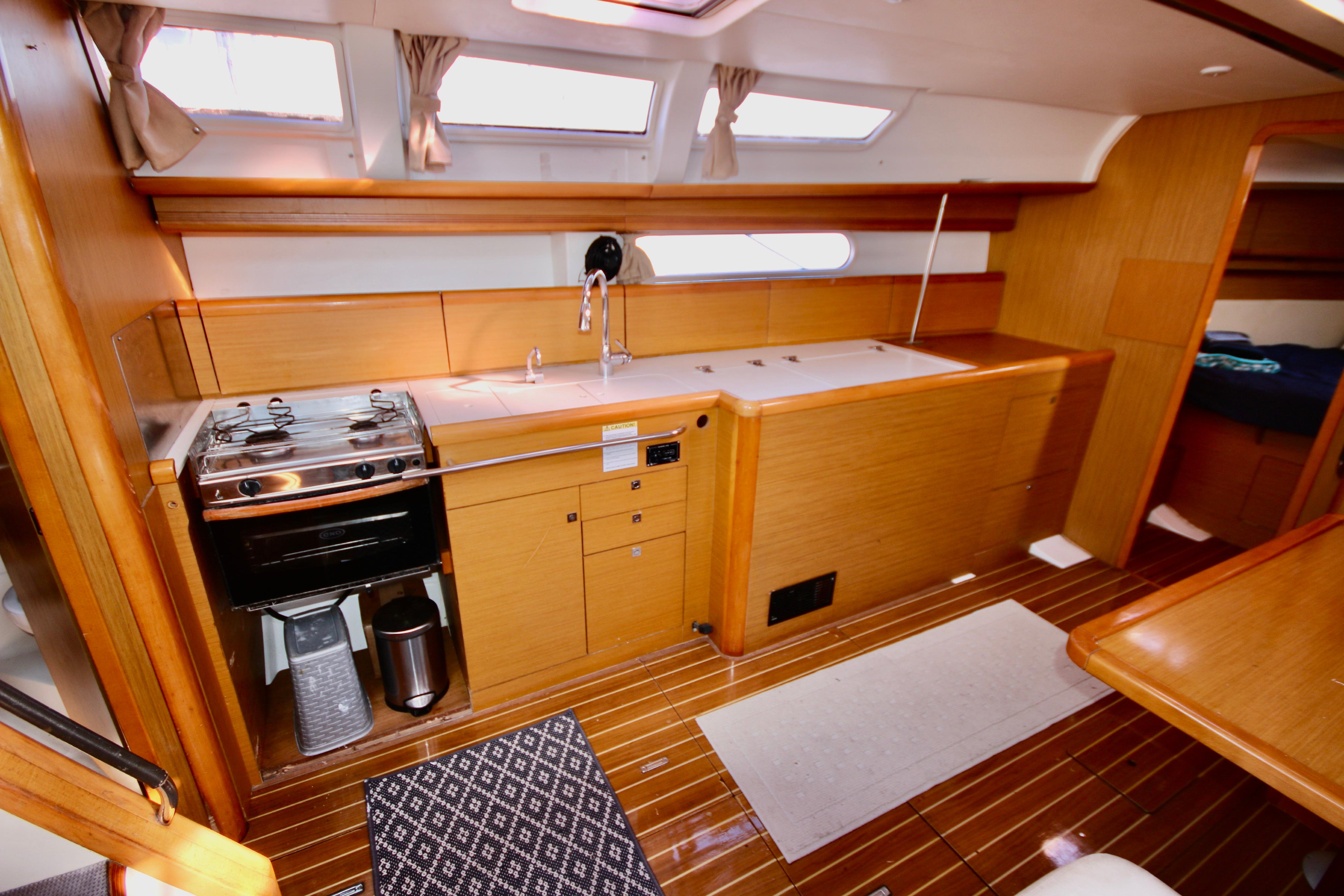 Interior of 2009 Jeanneau Sun Odyssey 44i yacht, featuring a modern kitchen galley.