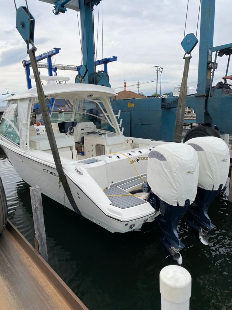 2023 Cobia 330 boat docked with dual engines.