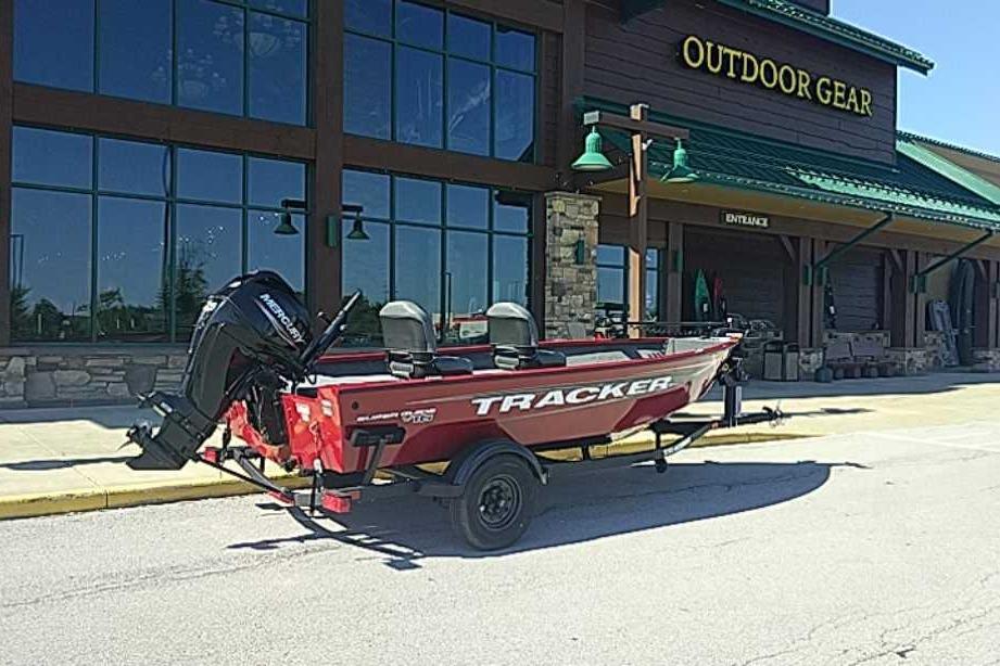 2026 Tracker Super Guide V-16 T boat parked outside outdoor gear store.