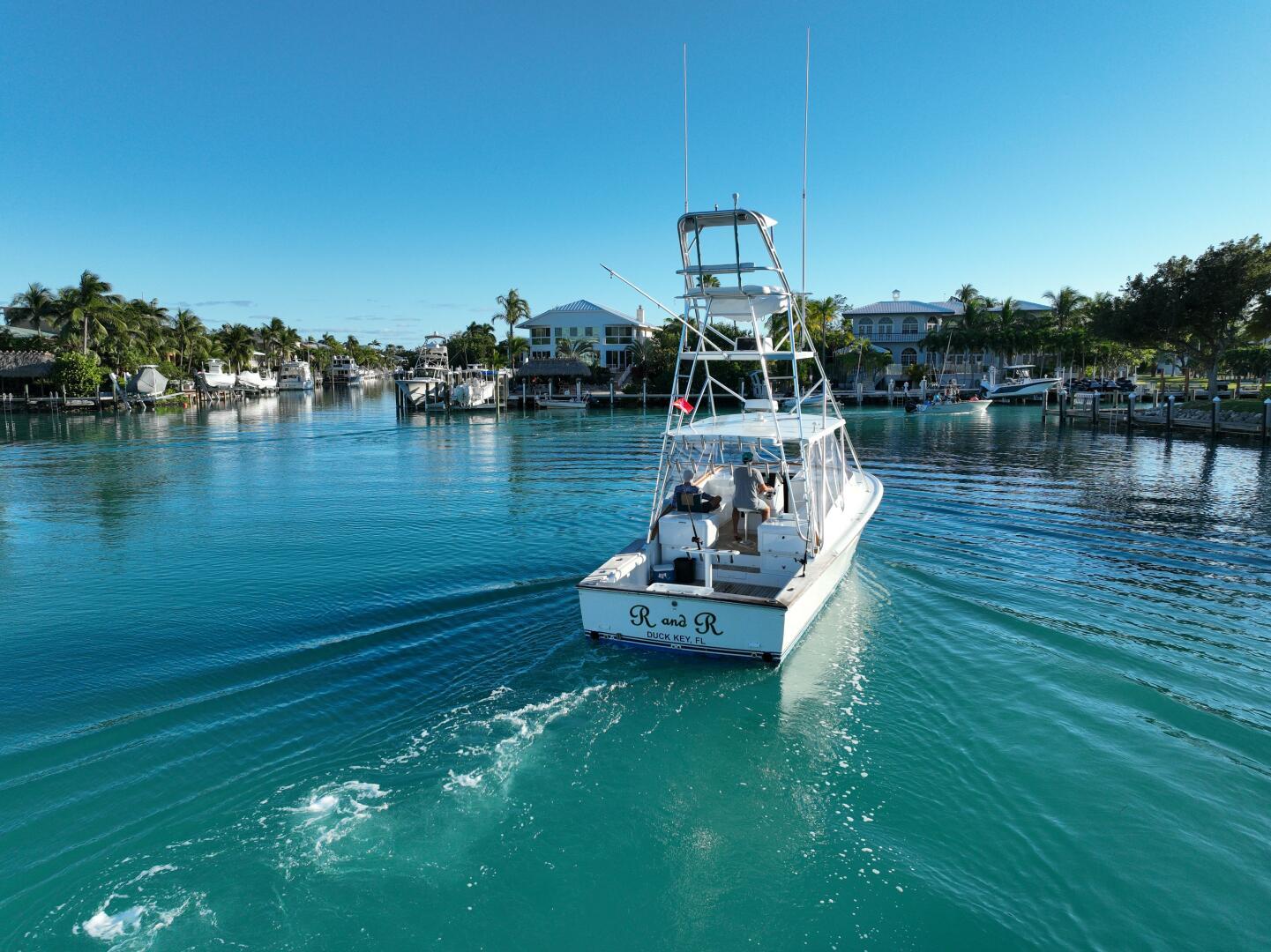 2000 Stolper 3800 Tournament Express boat cruising in a serene marina setting.