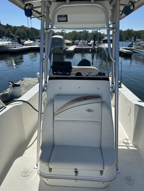 The image shows the cockpit of a 2000 Aquasport Osprey 250 boat docked at a marina.