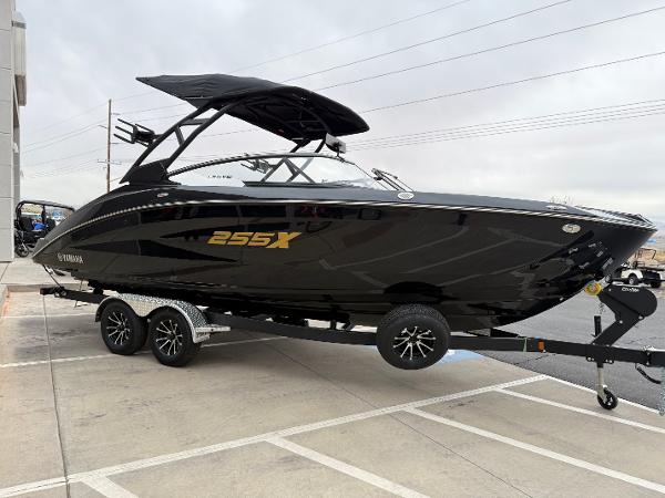 2025 Yamaha Boats 255XD, sleek black design on a trailer, parked outdoors.