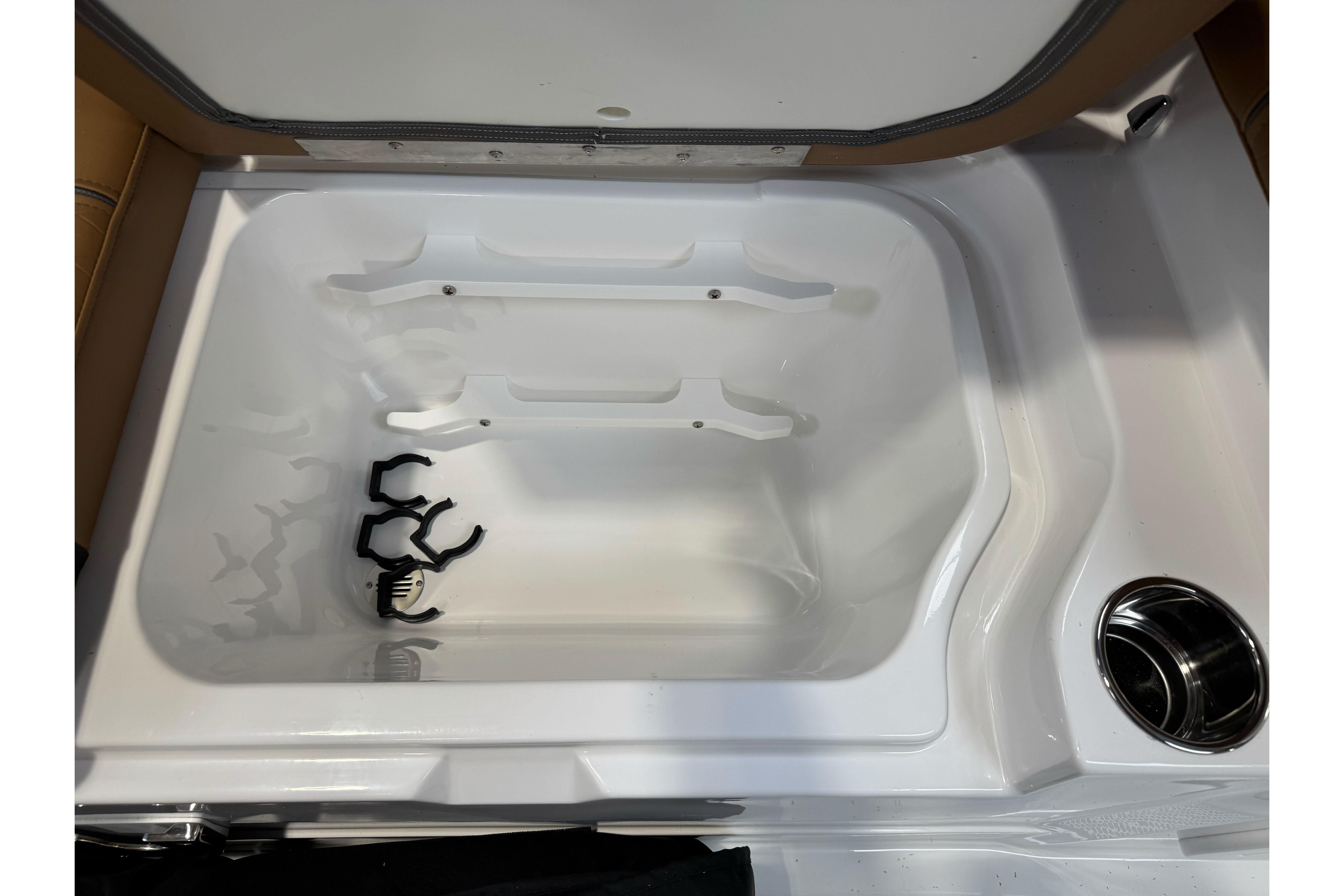Open storage compartment in 2026 Tahoe 2150 boat with cup holder.