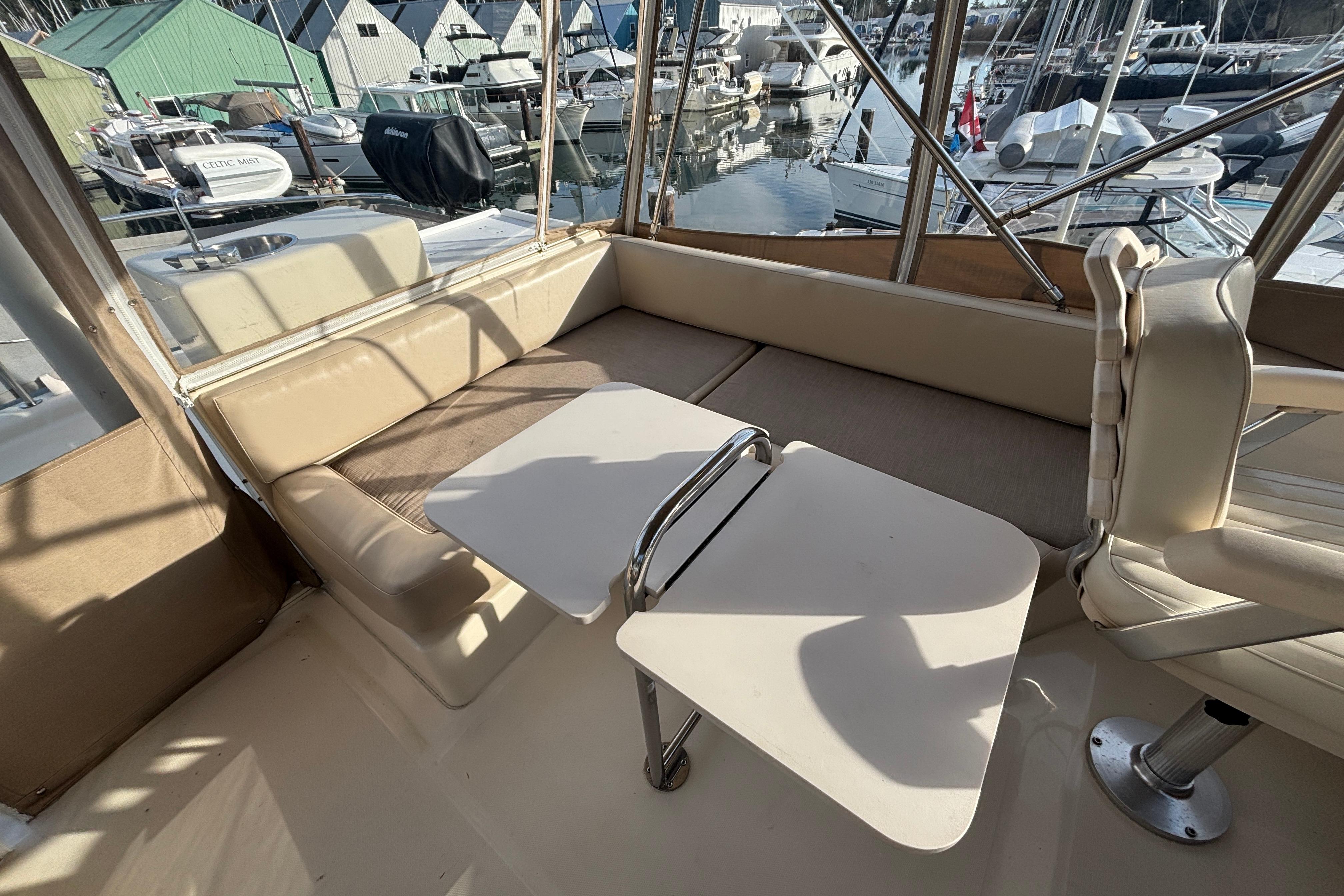 2007 Mainship 34 Trawler interior with seating and table, docked at marina.