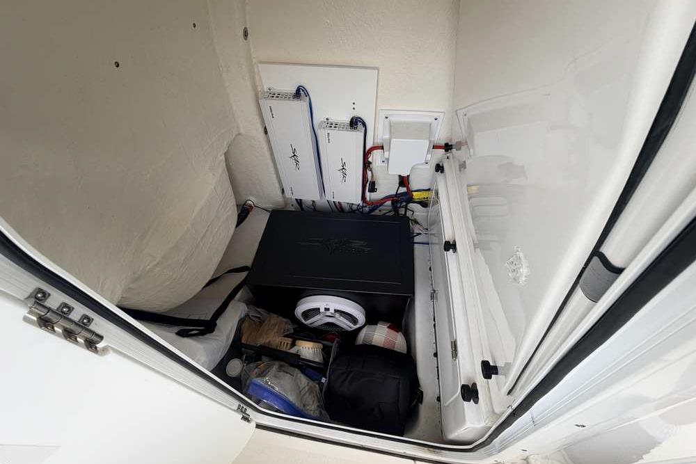 Storage compartment of 2024 Tidewater 232 LXF boat, featuring electrical components and equipment.