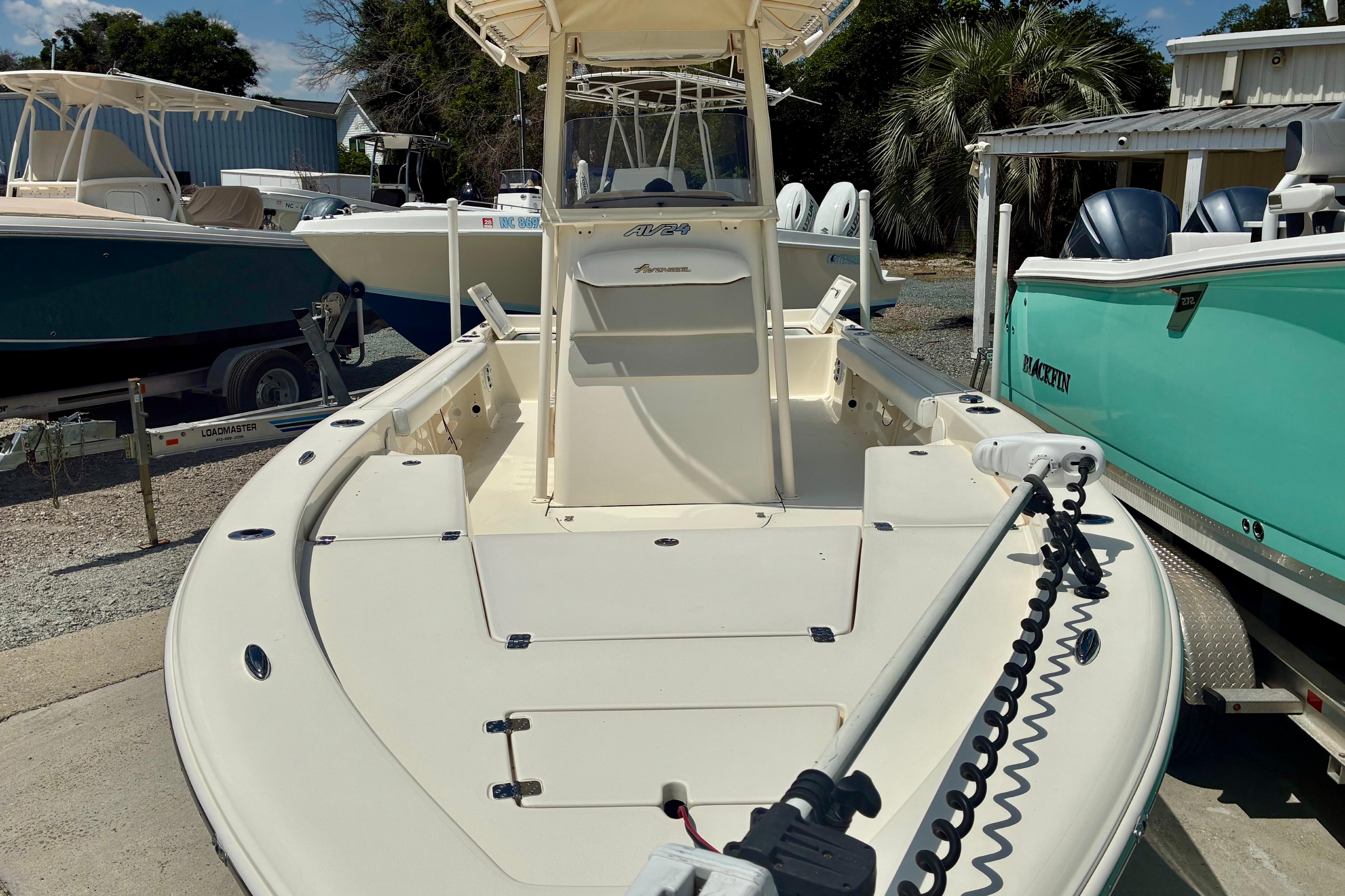 2018 Avenger AV24 boat with trolling motor, docked among other boats.