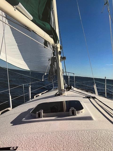 1983 Irwin Citation 34 sailboat on open water with clear blue sky.