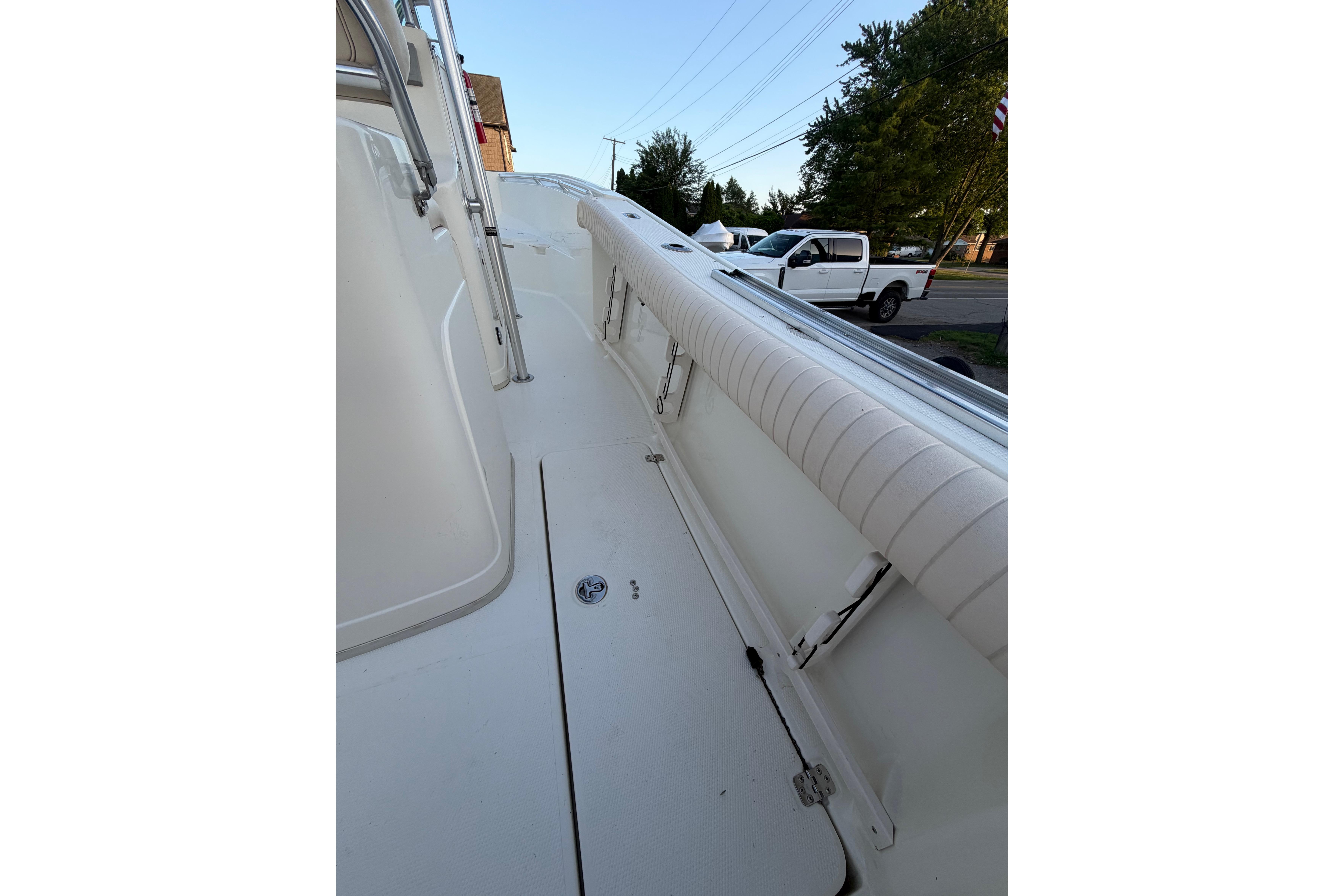 2007 Mako 234 Center Console boat deck with white railing and outdoor setting.