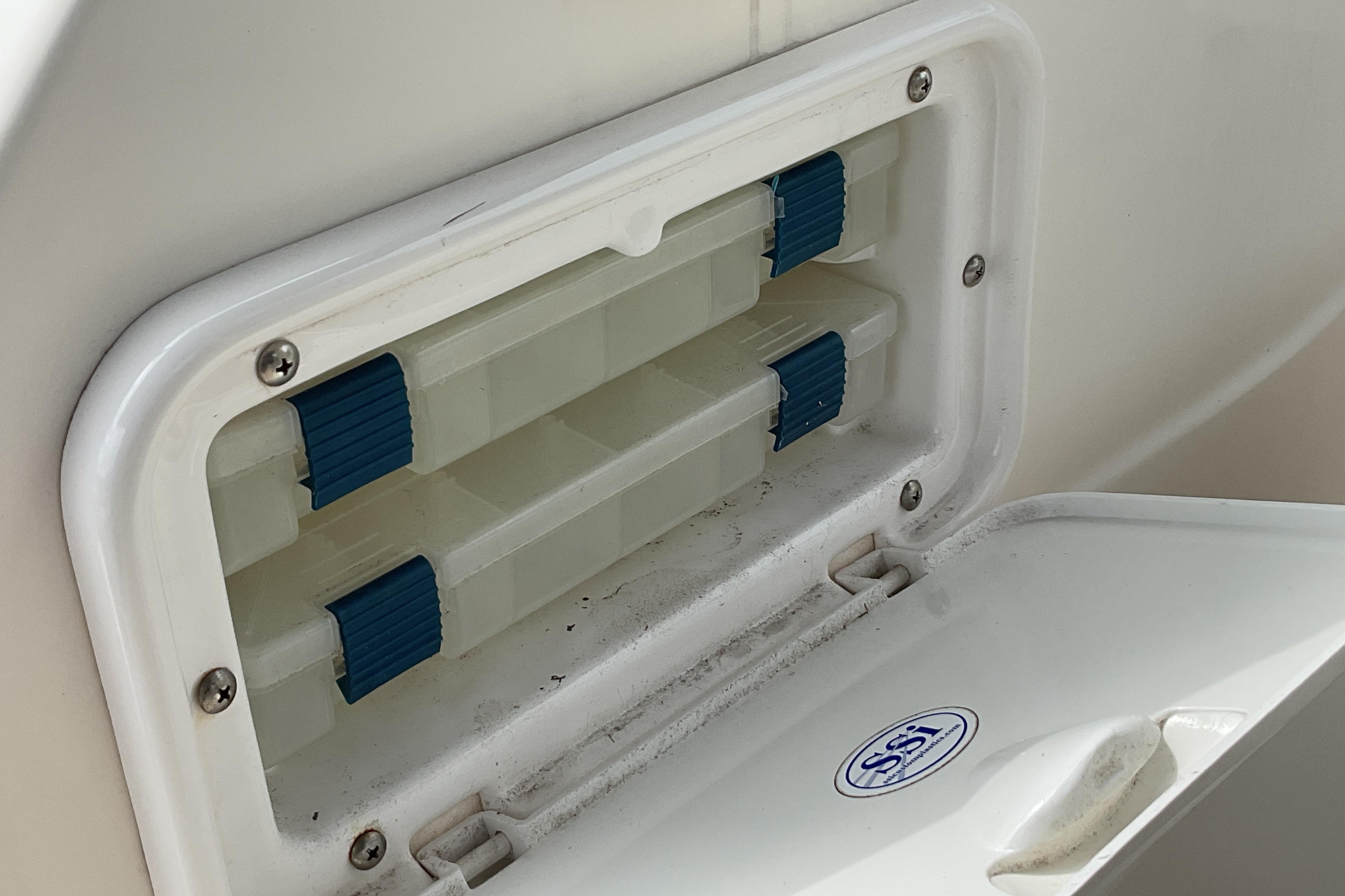 Storage compartment on a 2012 Wellcraft 232 Coastal boat with blue latches.