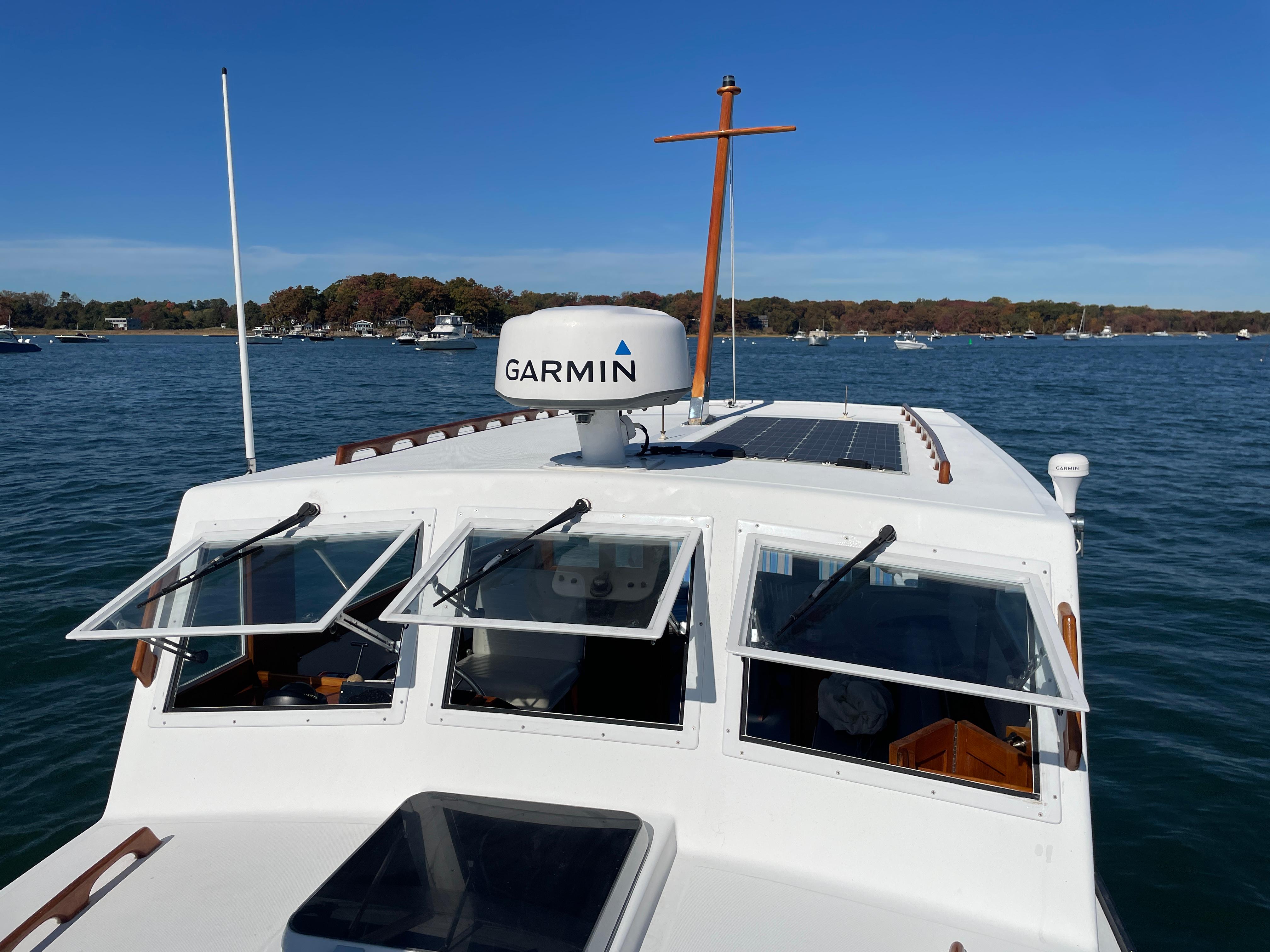 1988 Ellis 28 boat with Garmin radar on calm water under clear blue sky.