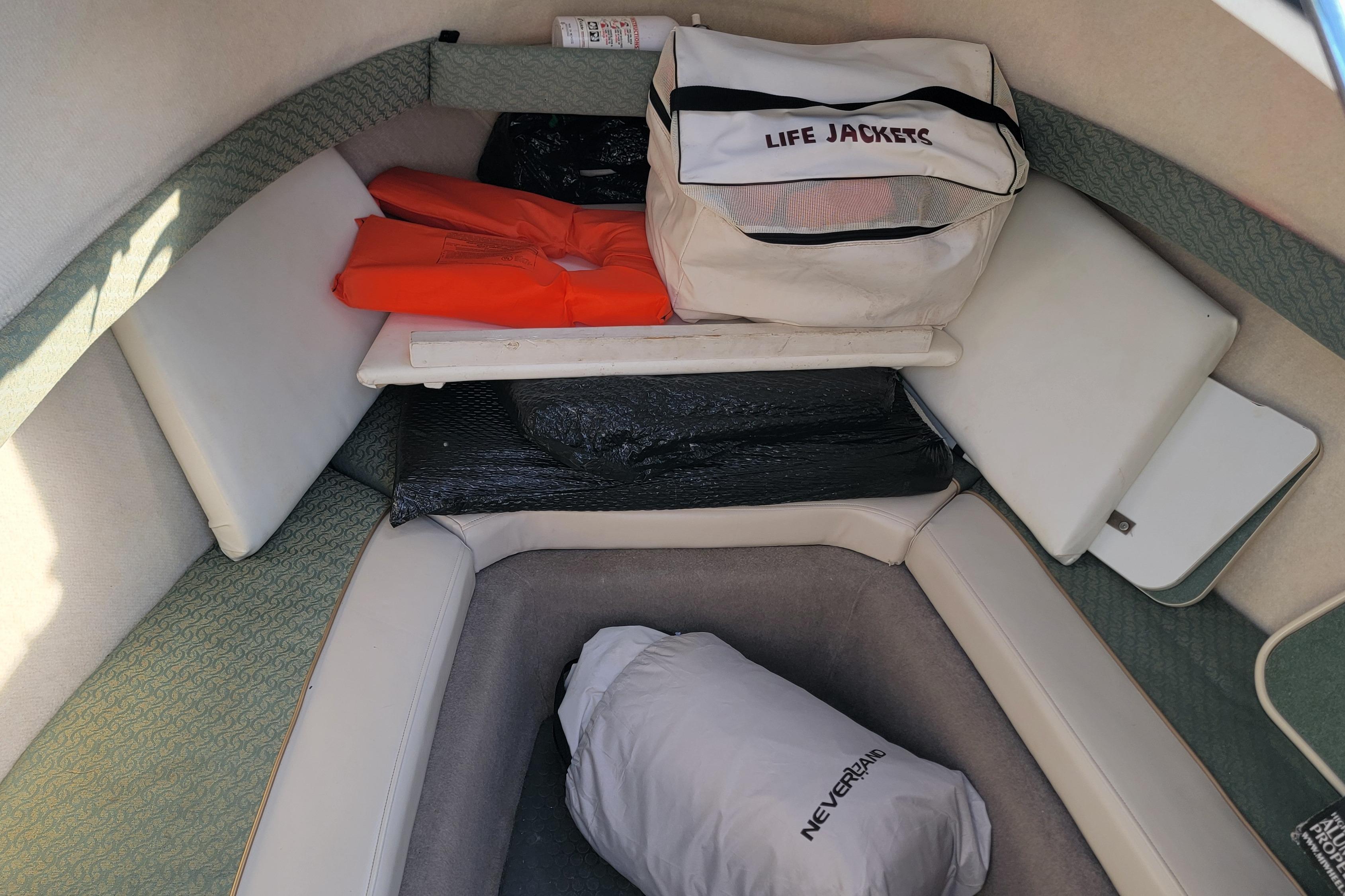 Interior of a 2003 Trophy 2002 Walkaround boat with life jackets and storage.