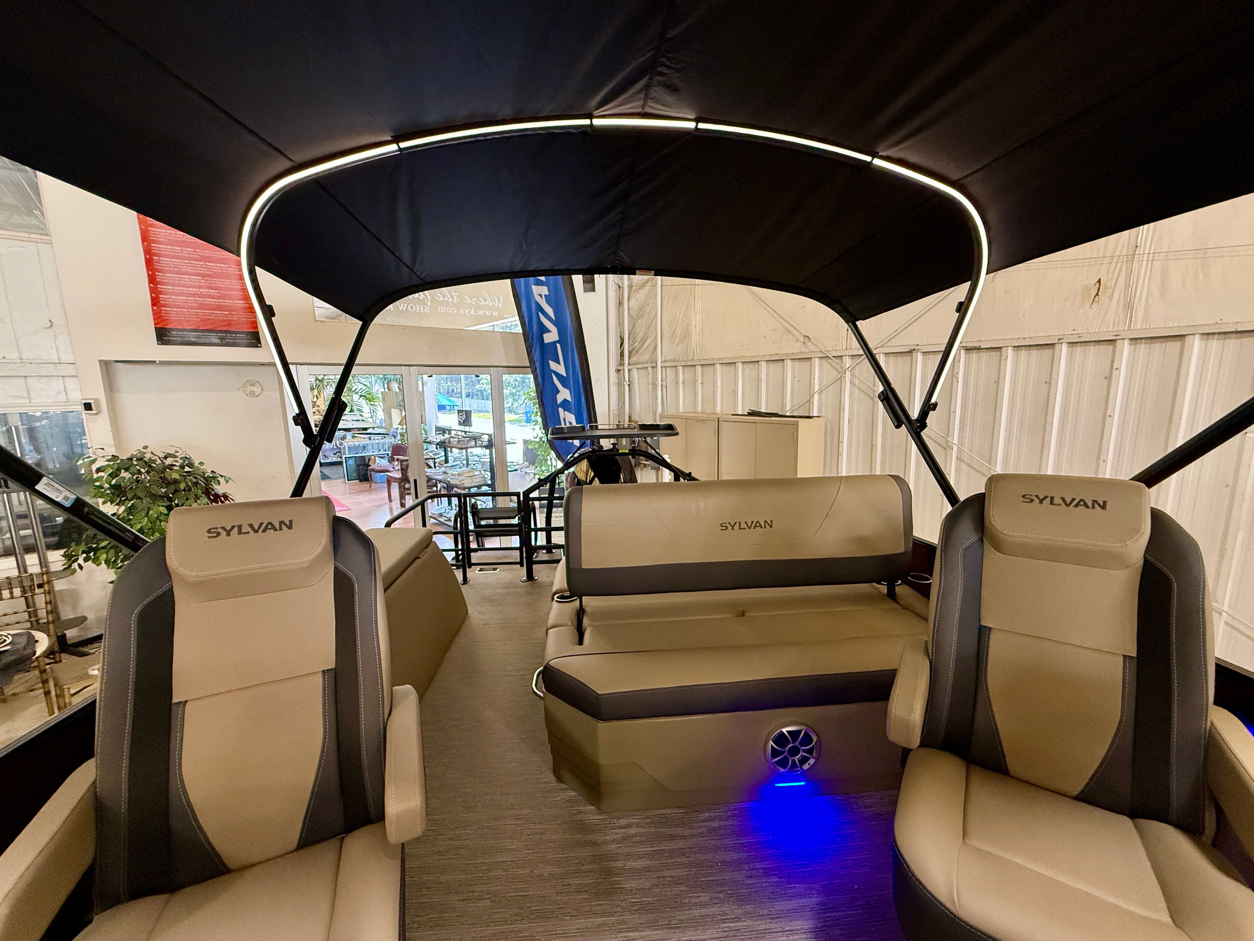 Interior view of a Sylvan X1 CLZ DH boat with beige seats and a black canopy.