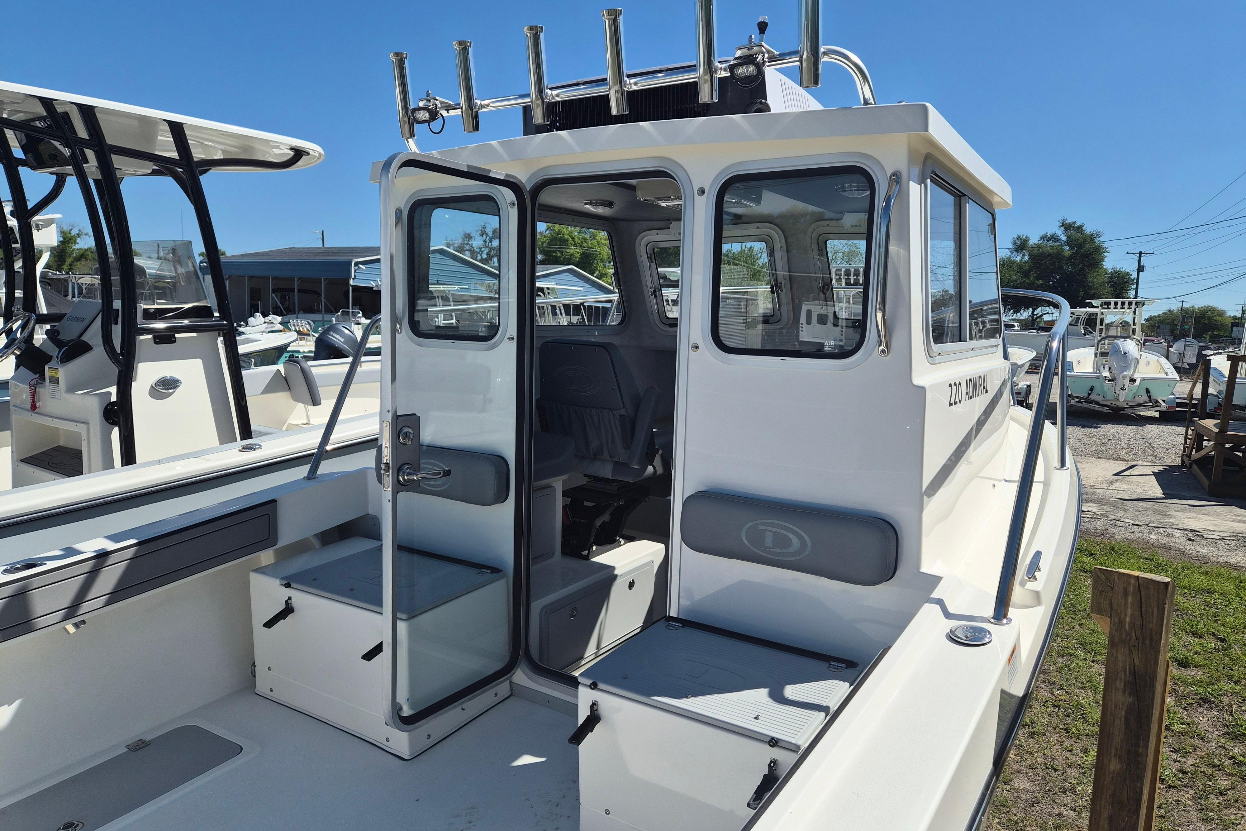 2026 Defiance Admiral 220 EX boat with open cabin door, docked under clear blue sky.