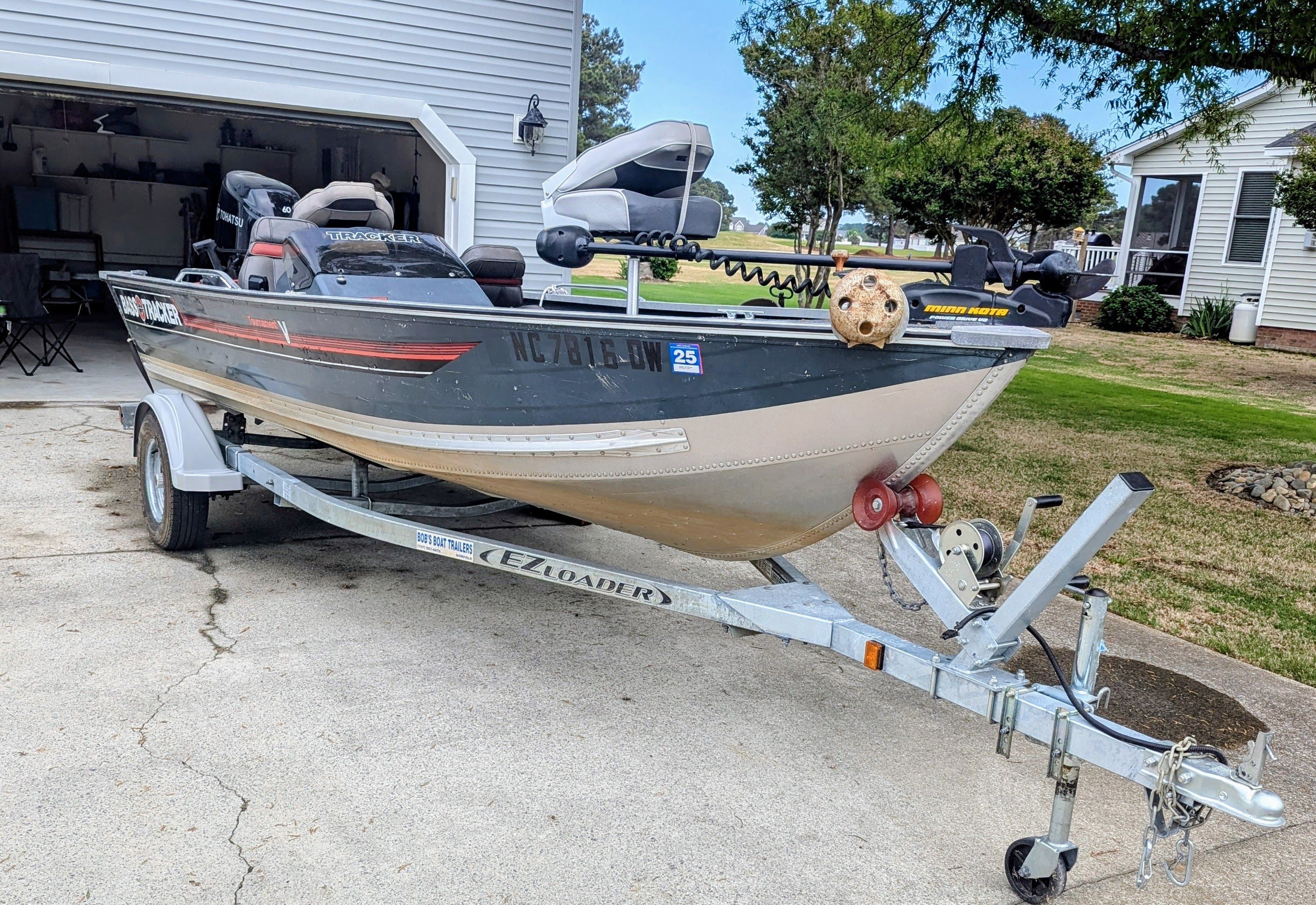 A 1988 Bass Tracker Tournament V on a trailer in front of a garage.