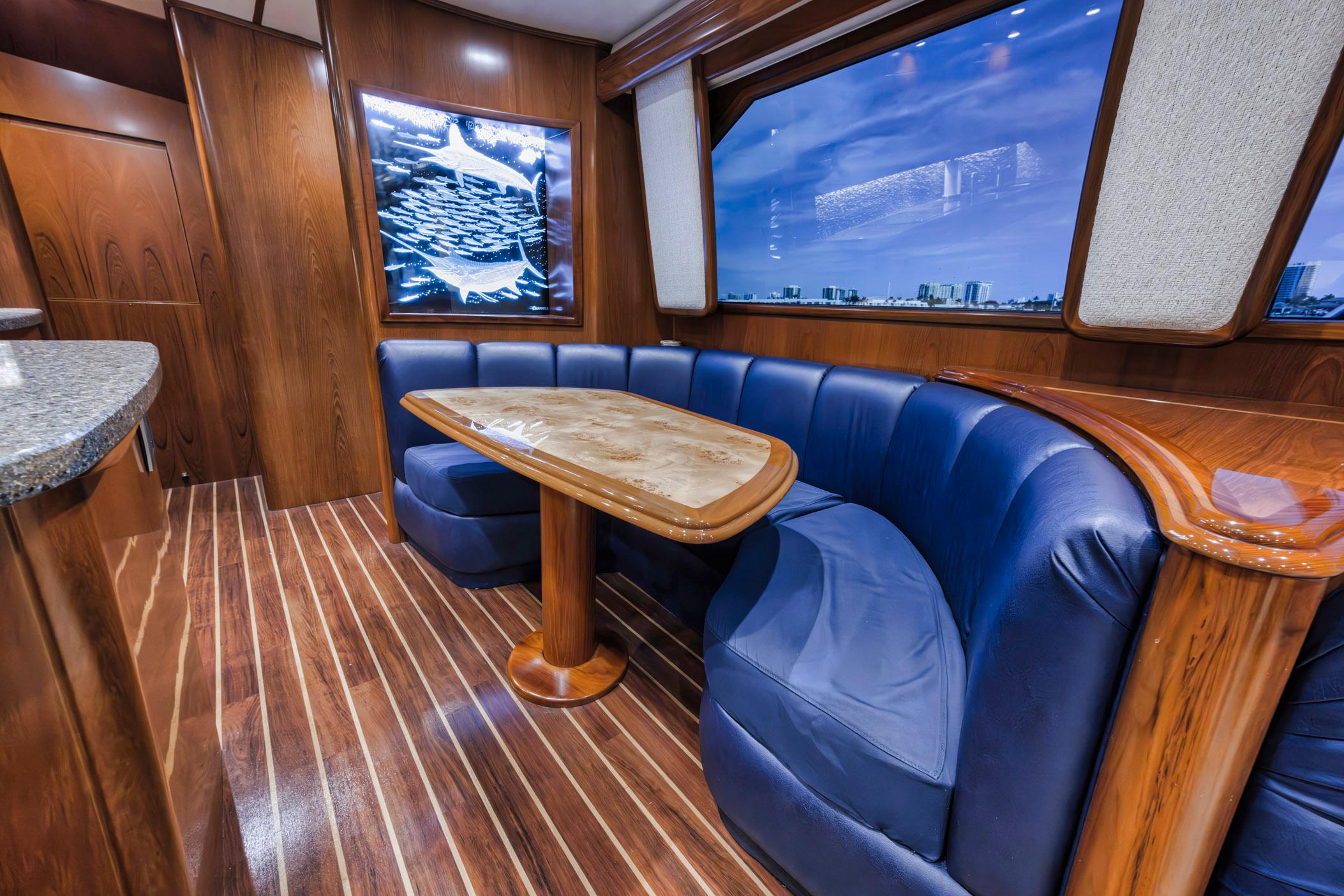 Luxurious interior of 2015 Viking 70 Convertible yacht with blue seating and wooden accents.