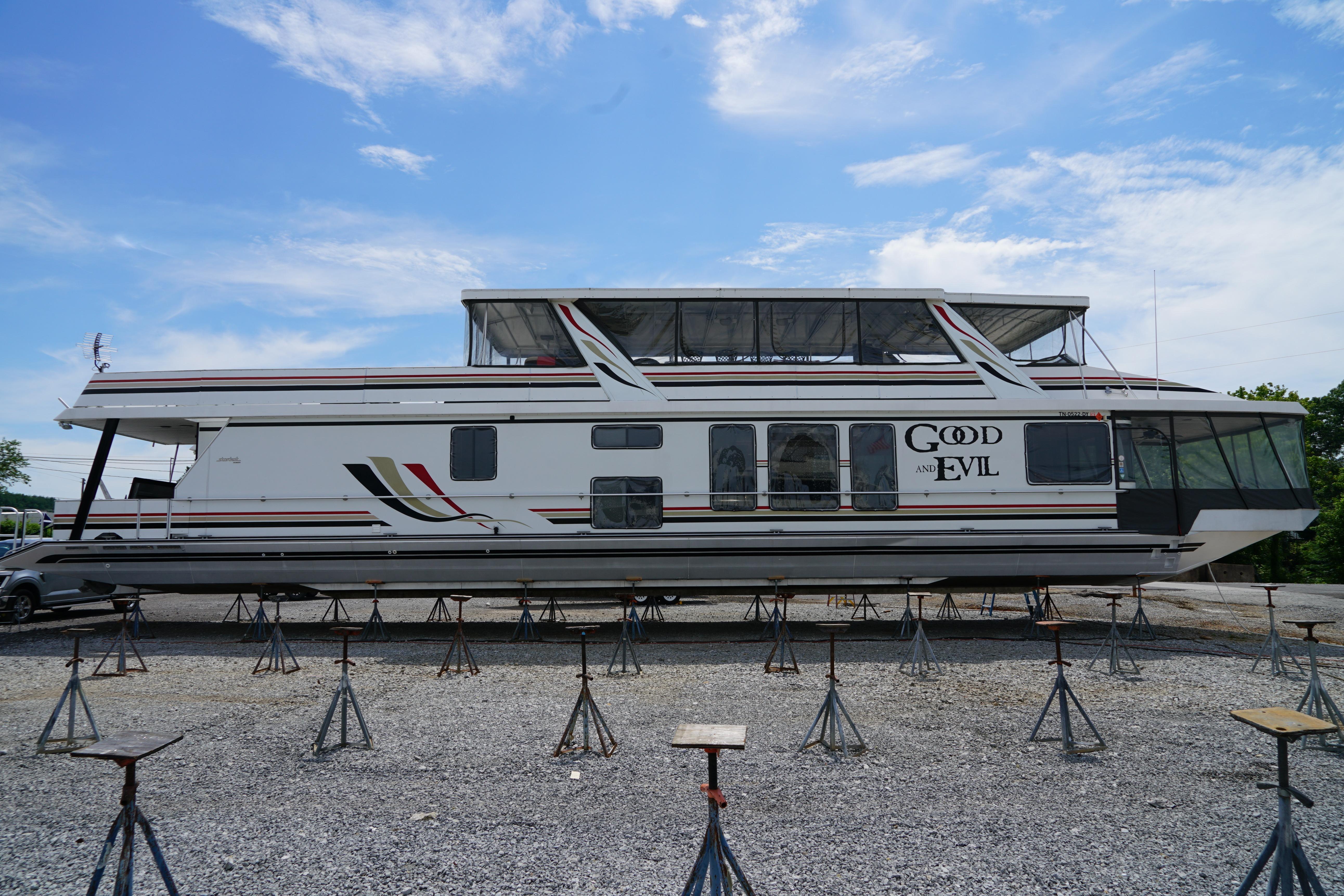 2000 Stardust Cruisers 83'x17' houseboat on stands, clear sky background.