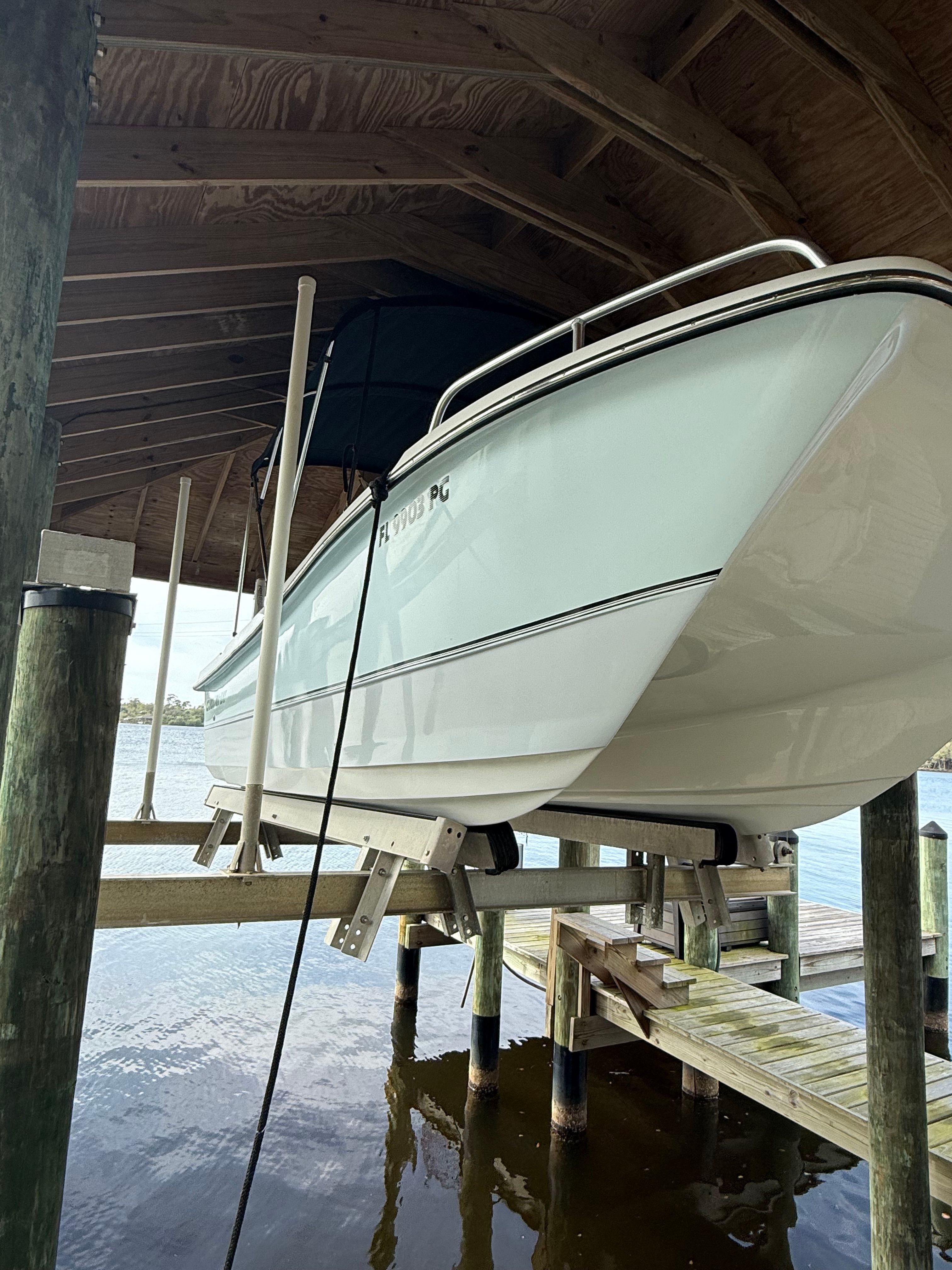 A 2011 Carolina Cat 18CC boat is on a boat lift above the water.