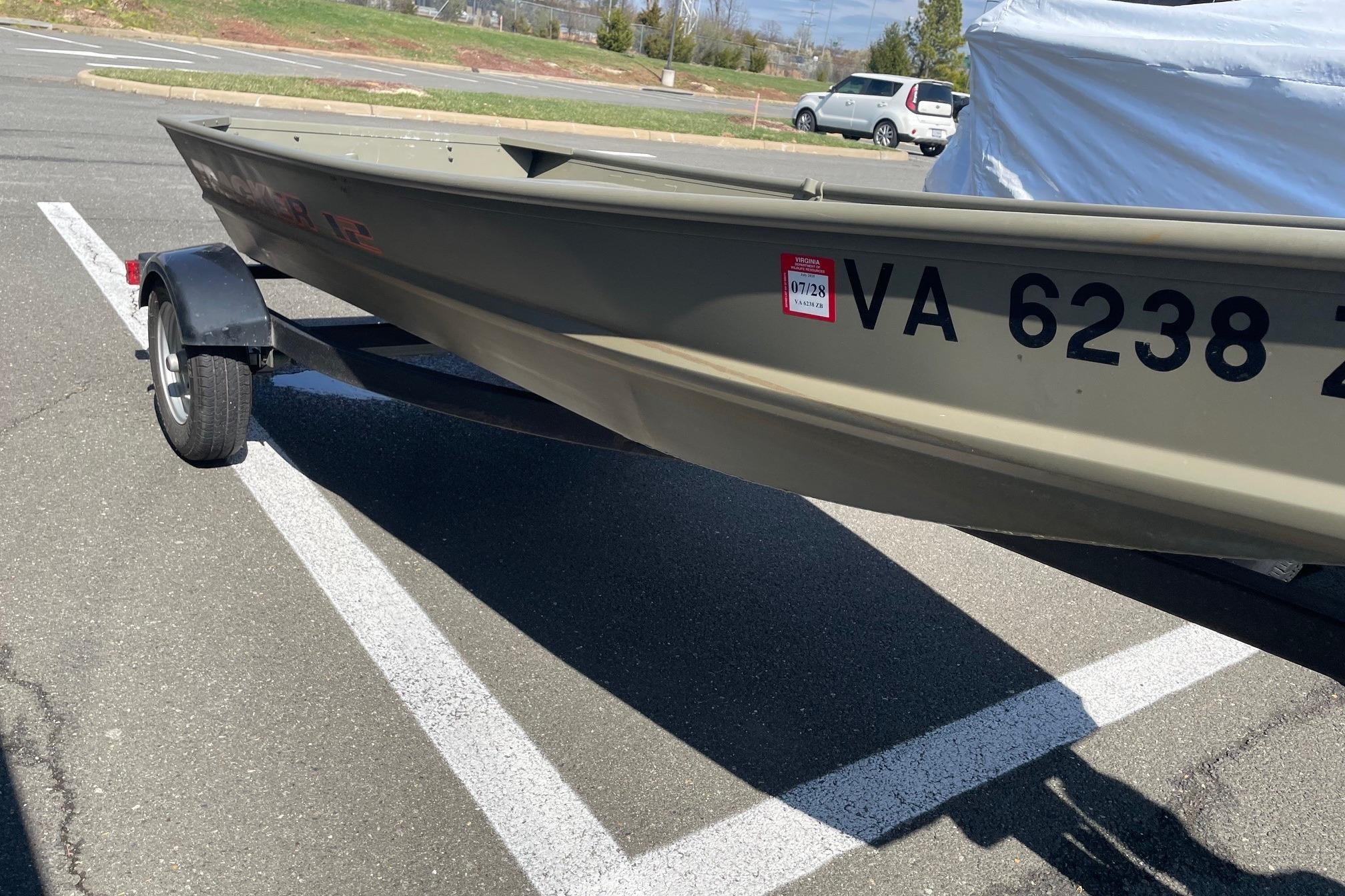 2025 Tracker Grizzly 1236 Jon boat on trailer in parking lot.