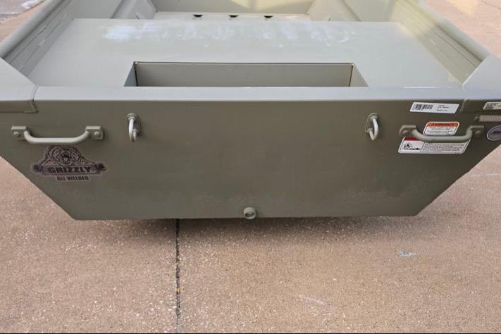 2026 Tracker Grizzly 14 Jon boat, rear view, on concrete surface.