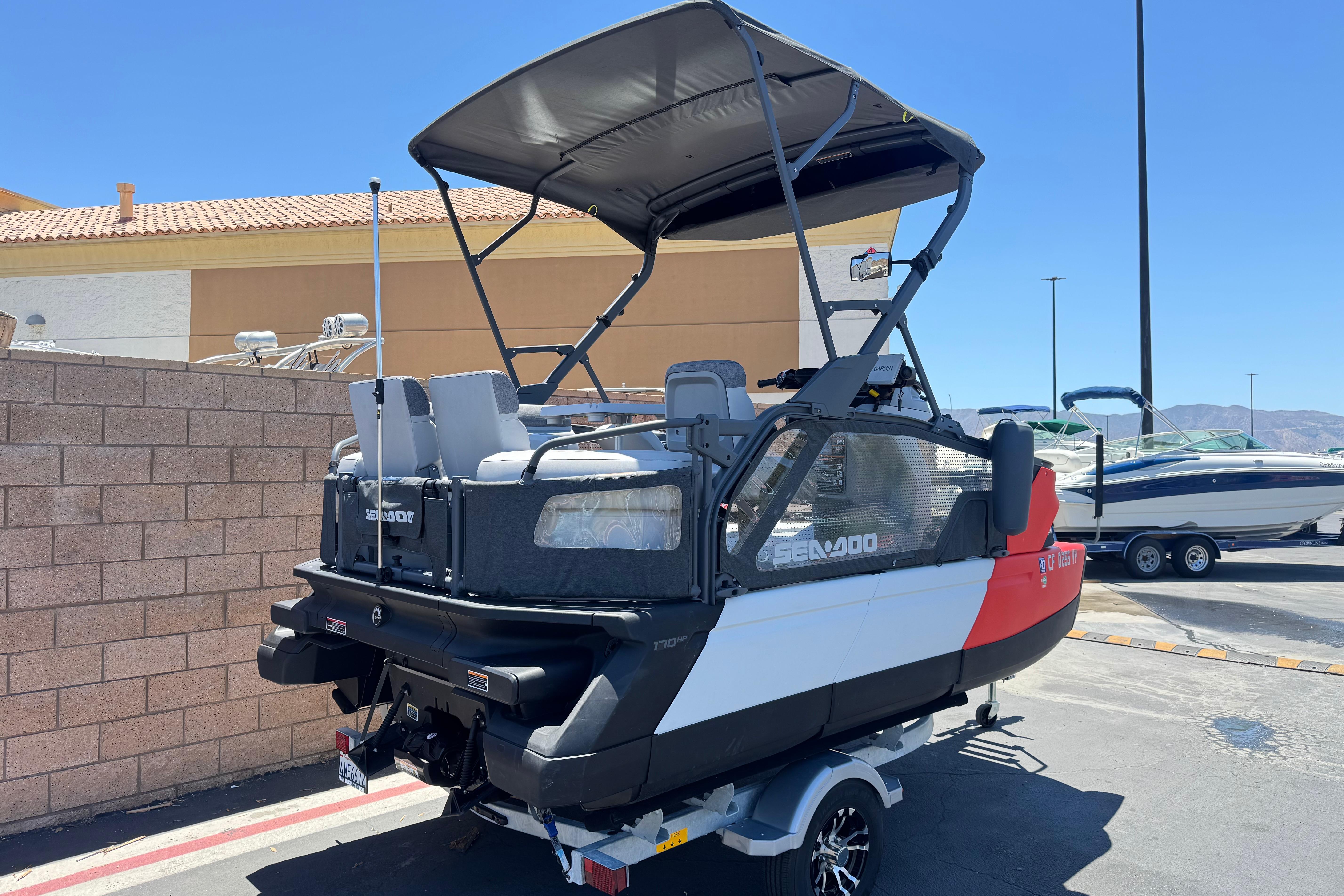 2024 Sea-Doo Switch Compact boat on trailer, parked outdoors under clear blue sky.
