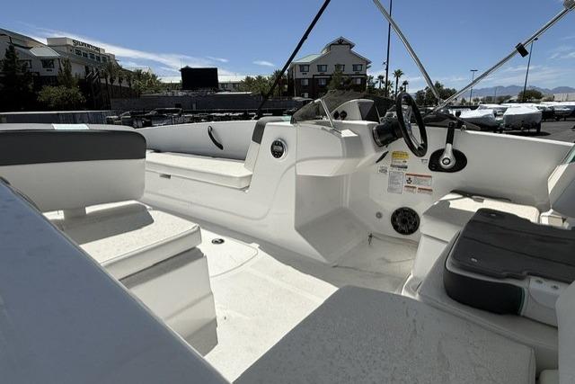 2026 Tahoe T18 boat interior with seating and steering wheel, parked outdoors.