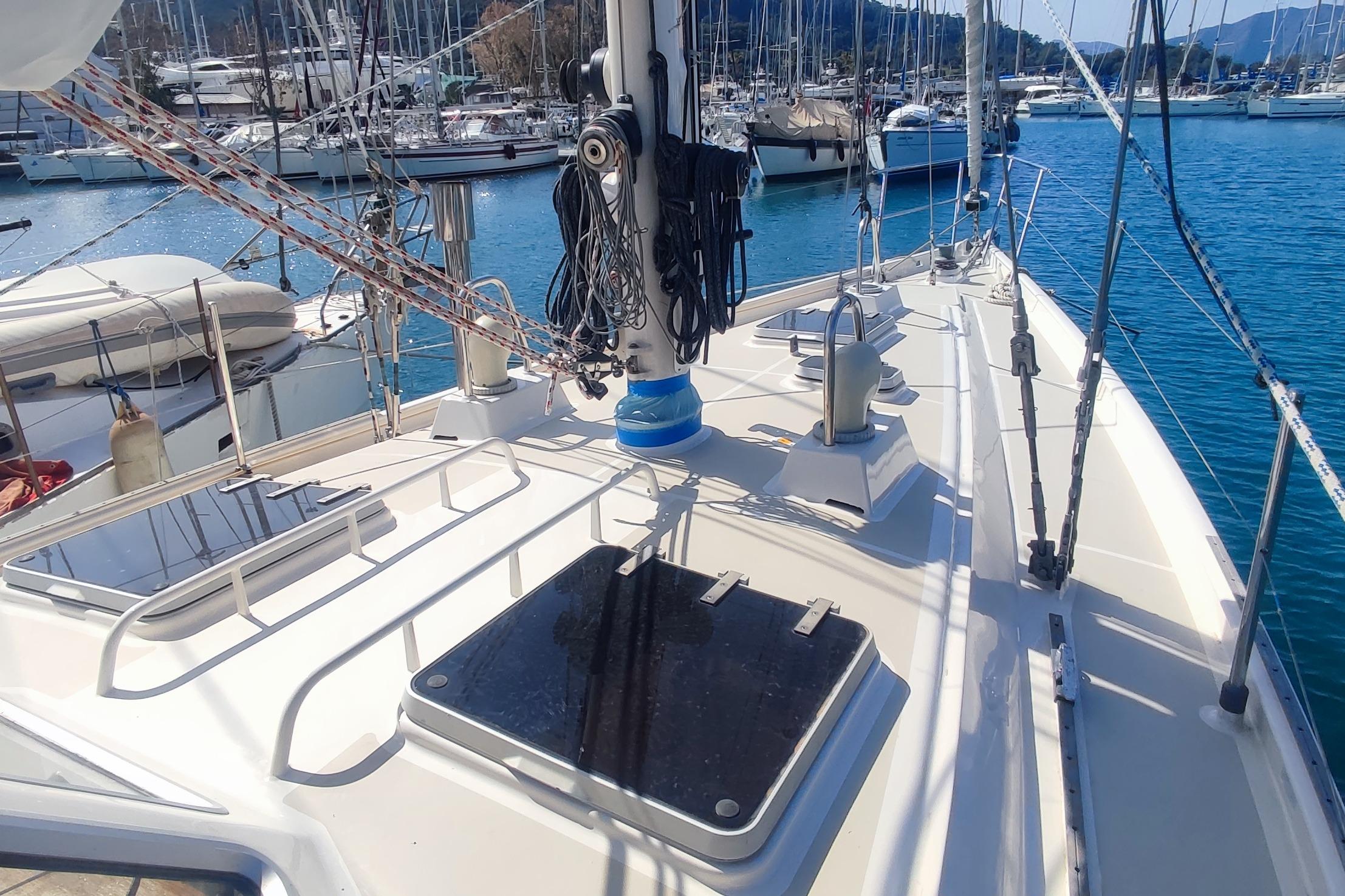 Sailboat deck view of 1987 Custom Danish 44 in a marina, surrounded by other boats.