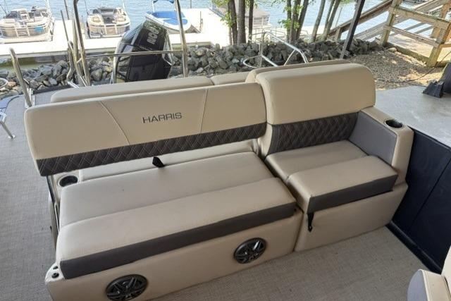 2025 Harris Sunliner 230 boat interior with beige seating and lake view.
