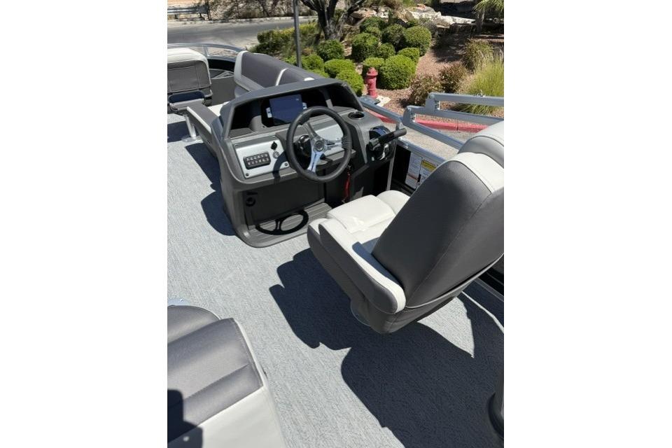2026 Sun Tracker Fishin' Barge 20 DLX interior with steering console and seating.