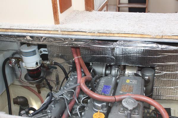 Engine room of a 1985 Nordic Tug 26 with visible hoses and insulation.