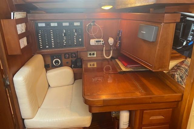 Navigation station in a 2001 Tartan 3700 sailboat with control panels and seating.