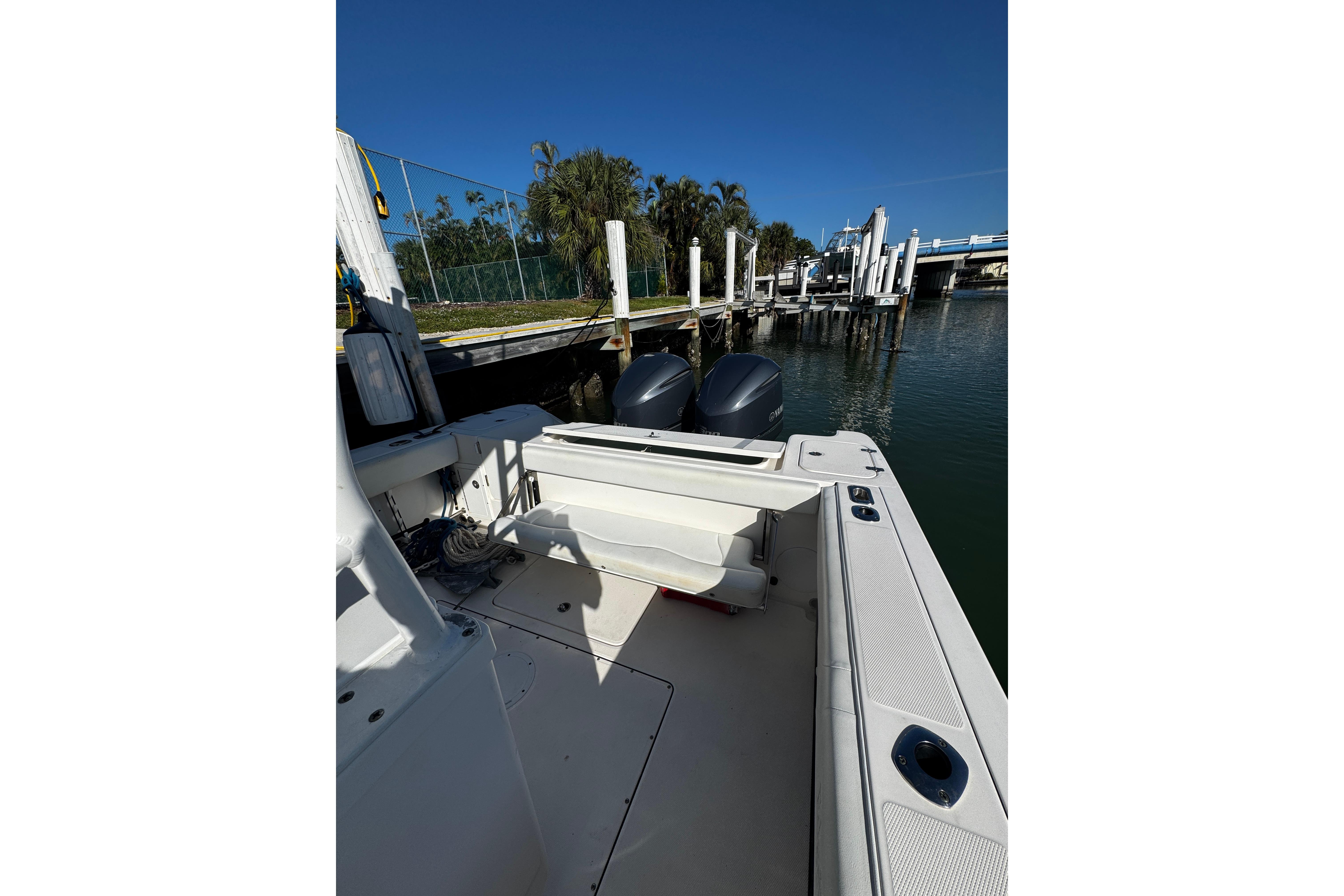 2015 Edgewater 320CC boat docked, featuring dual outboard motors and spacious deck.