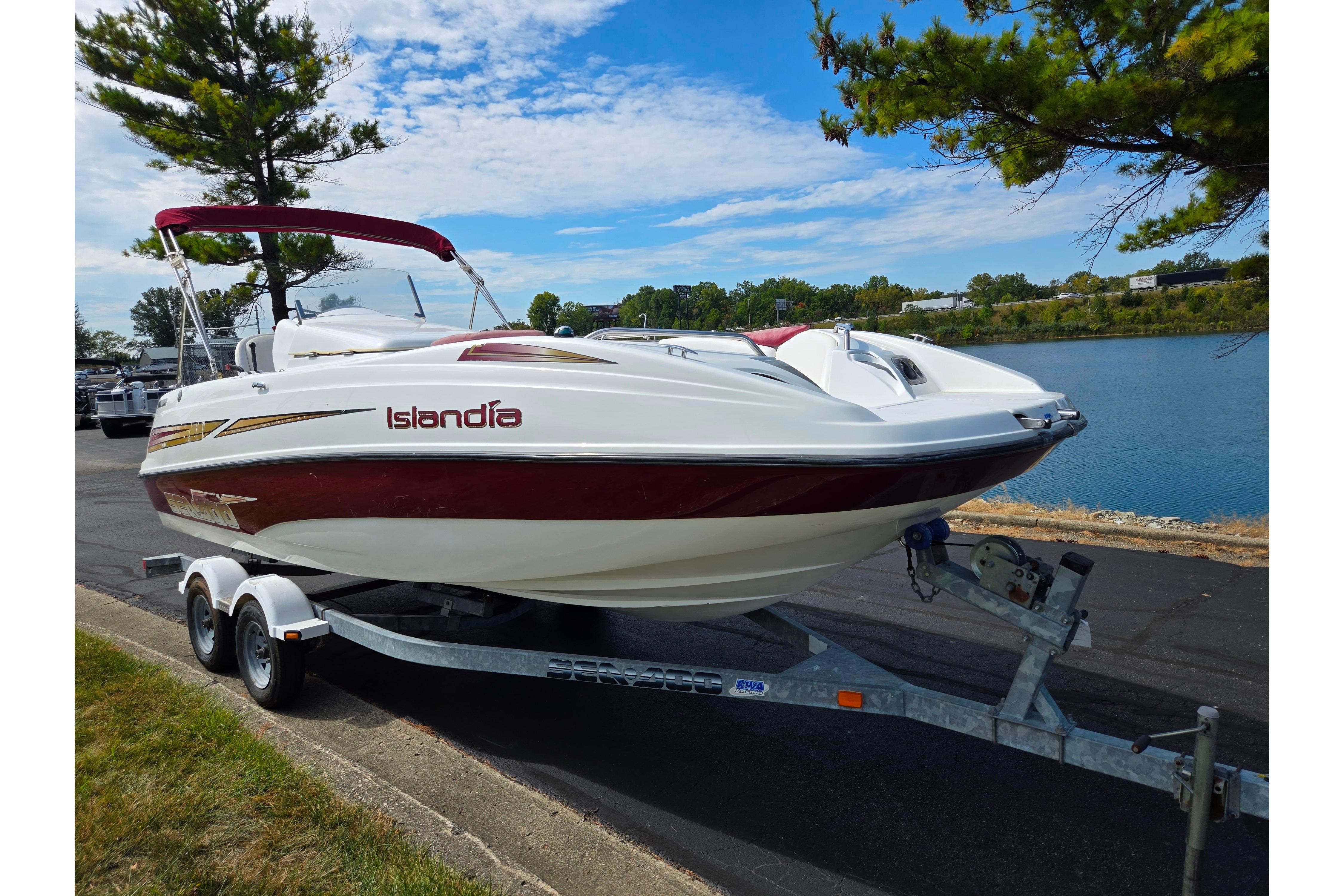 2004 Sea-Doo Islandia sport boat on trailer by a lakeside road.
