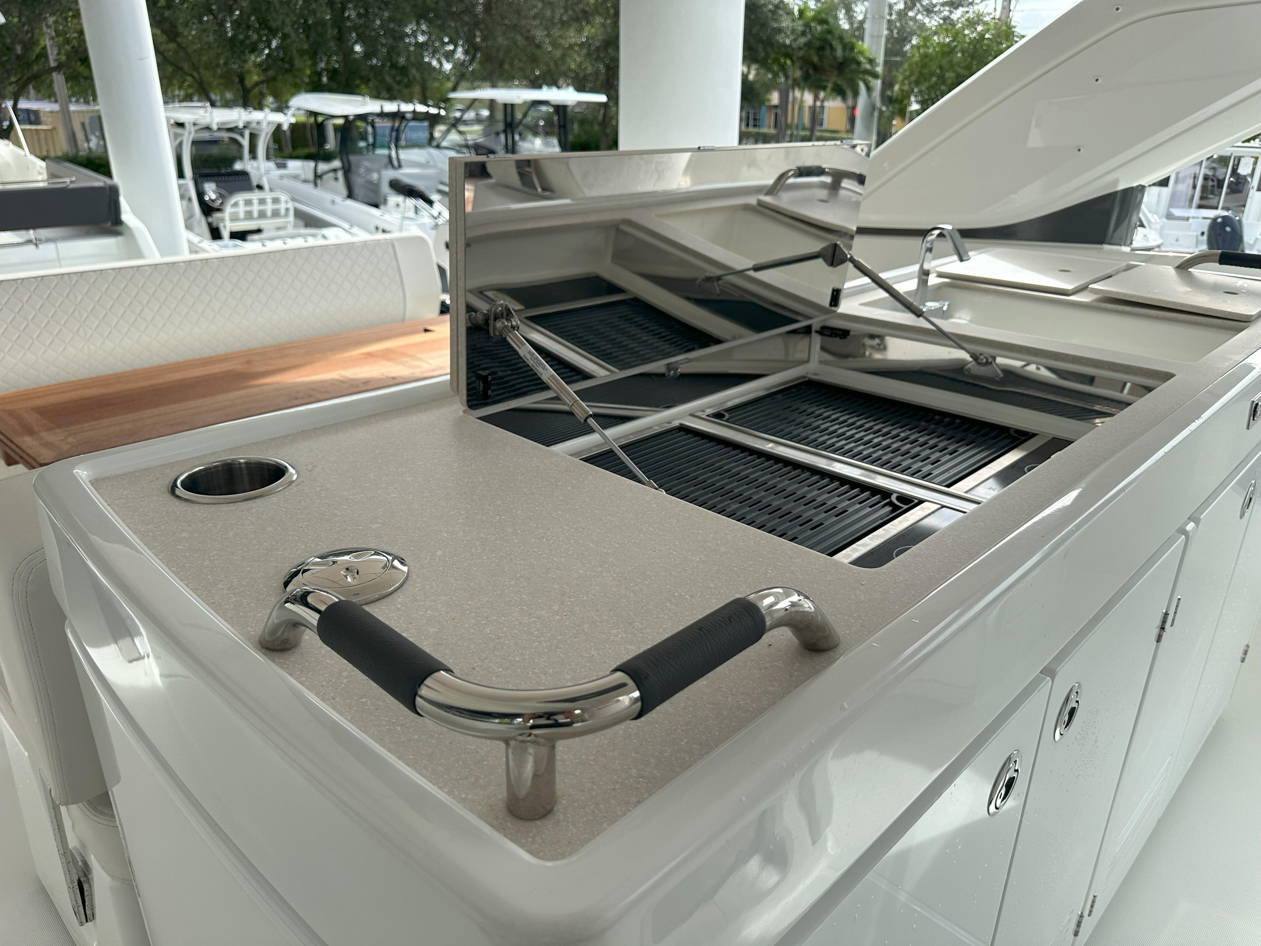 Outdoor kitchen area on 2024 Jeanneau DB 43 yacht with grill and storage.
