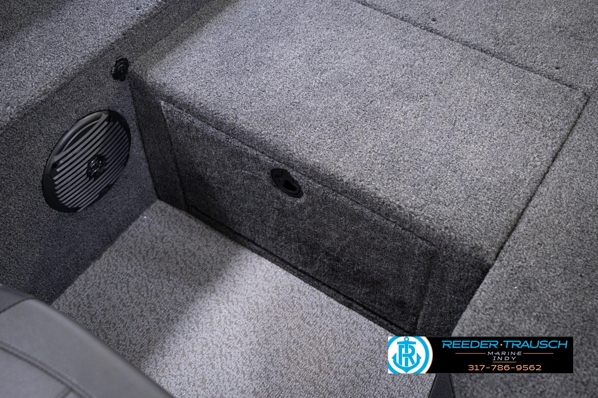 Interior of 2026 Lund 1775 Impact XS SS boat with carpeted storage and speaker.