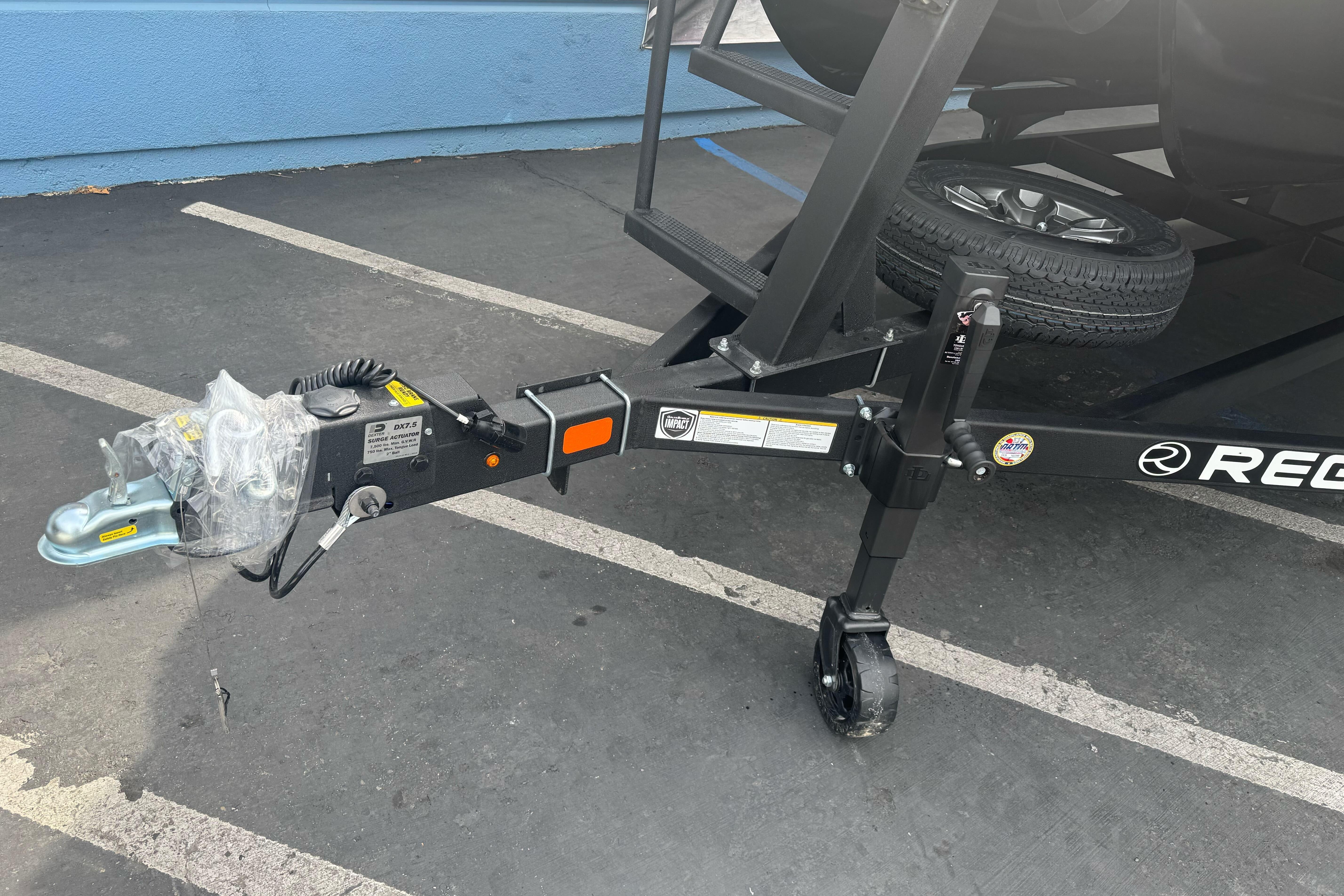 Trailer hitch of a 2026 Regency 250 DL boat, parked on asphalt.