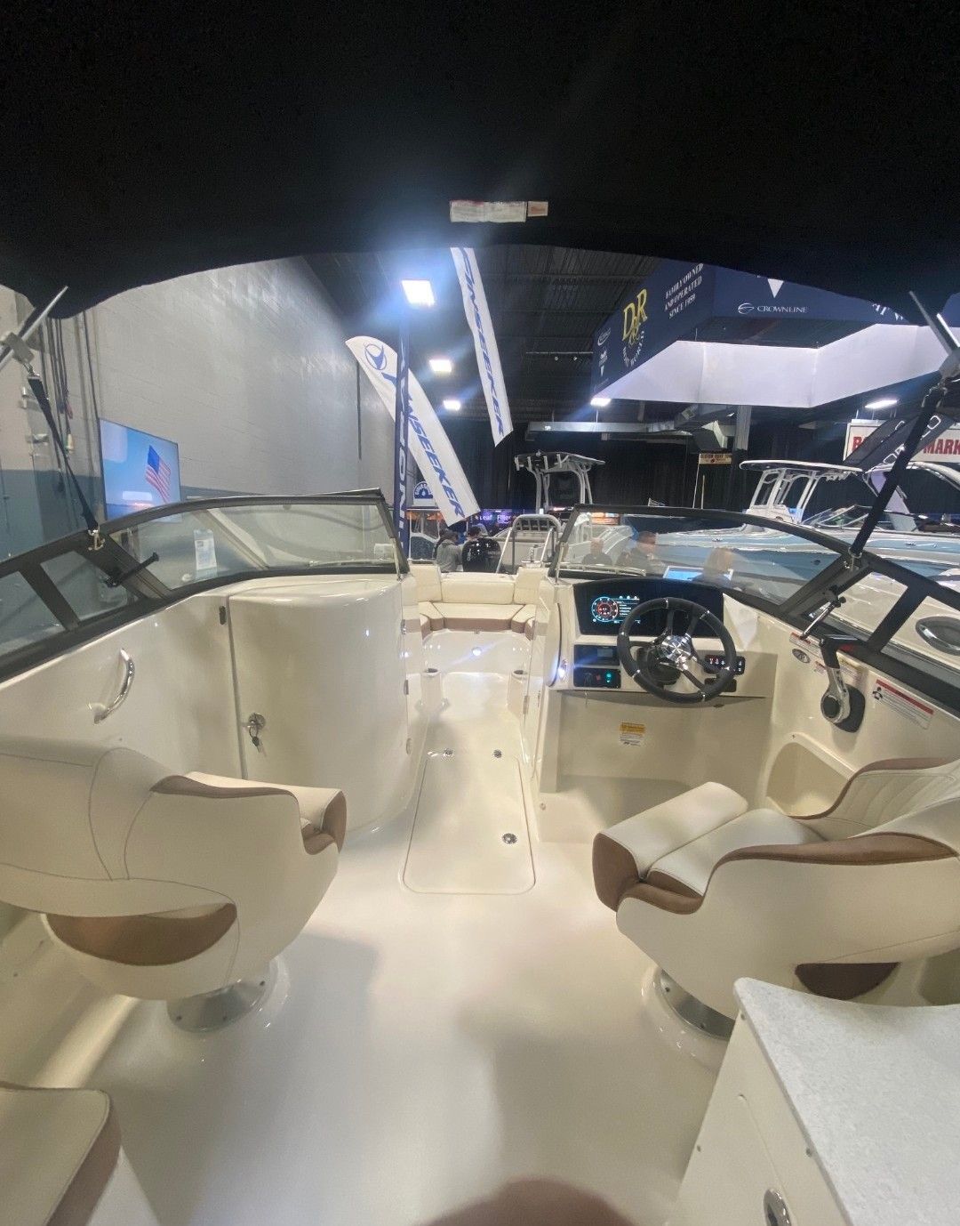 Interior view of a modern boat with two seats and a helm station.