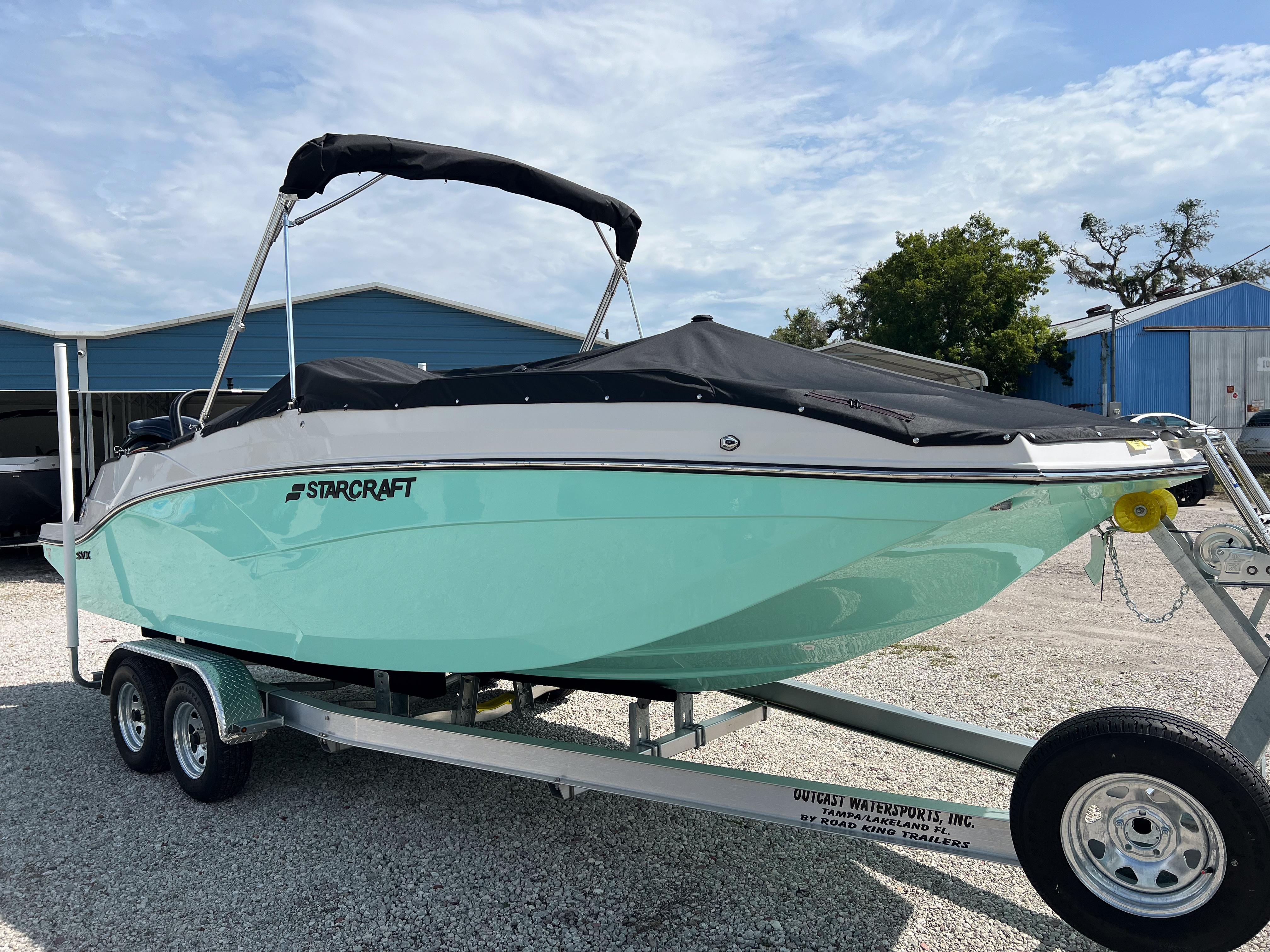 2026 Starcraft SVX 231 OB boat on trailer, parked outdoors under a cloudy sky.