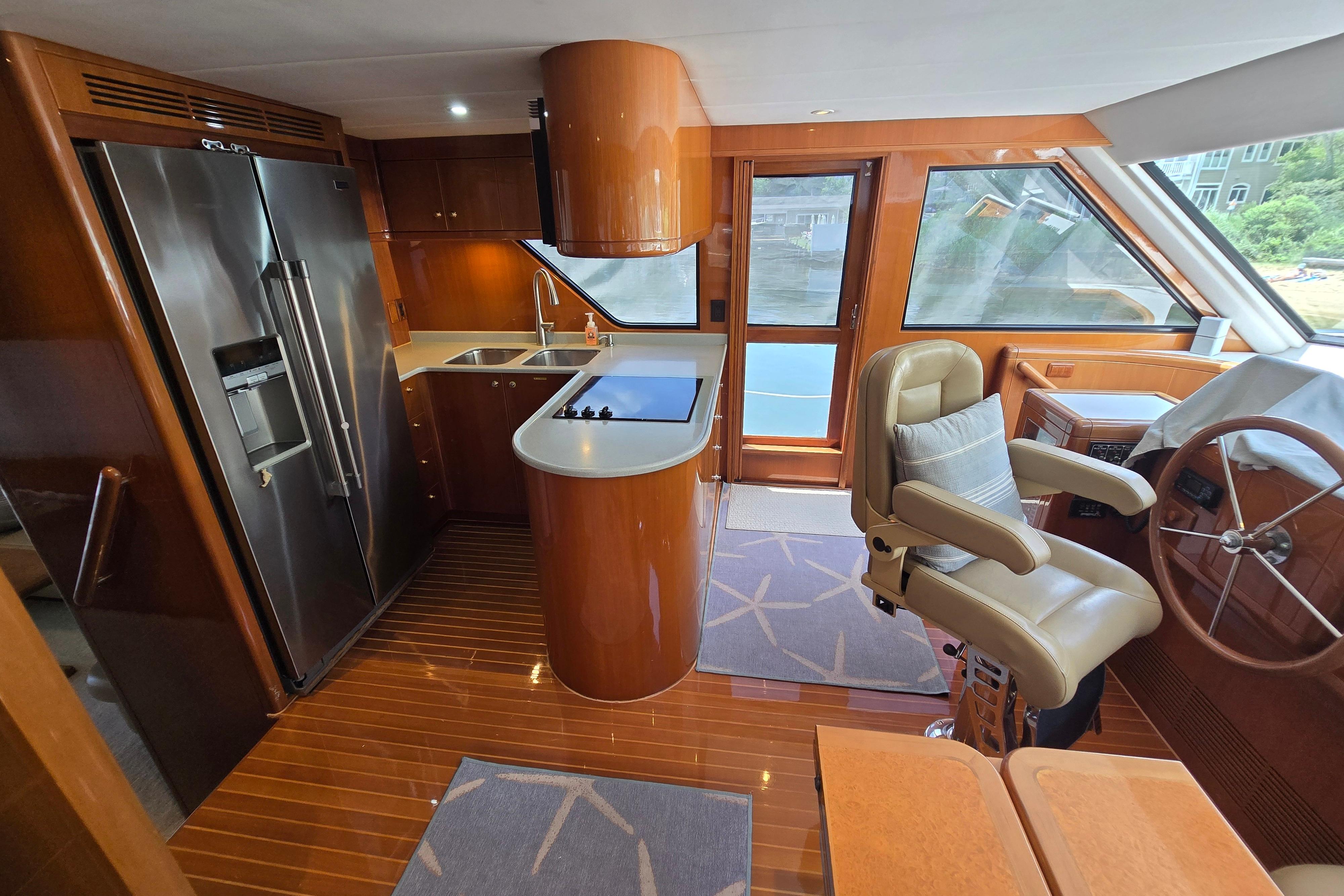 Luxurious 2004 Grand Harbour 58 yacht interior with modern kitchen and captain's chair.