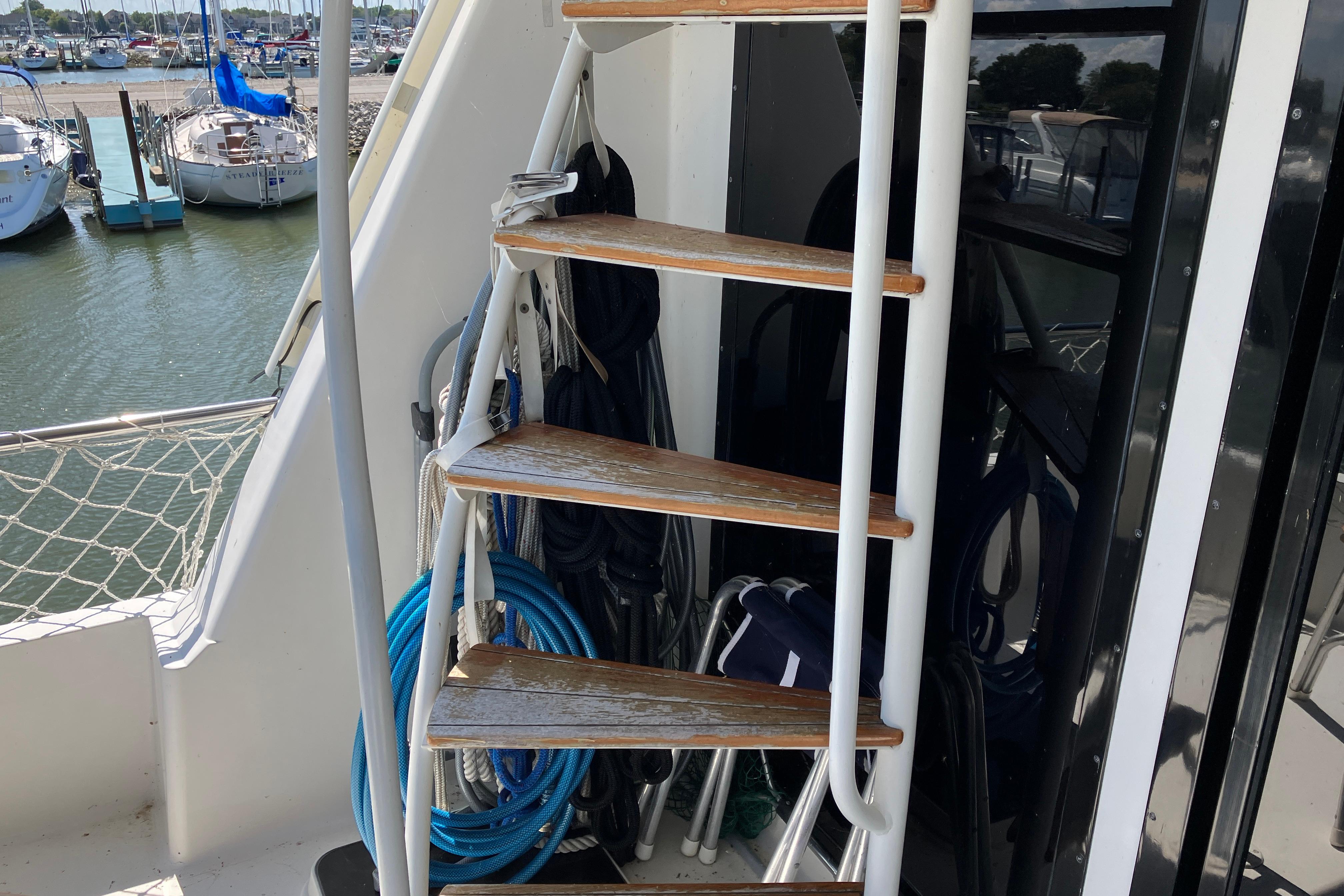 Staircase on 1995 Viking 50 Motor Yacht with marina view in background.