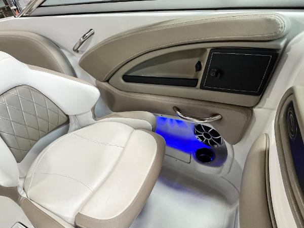 2023 Crownline Eclipse E235 XS interior with beige and white seating, blue LED lighting.