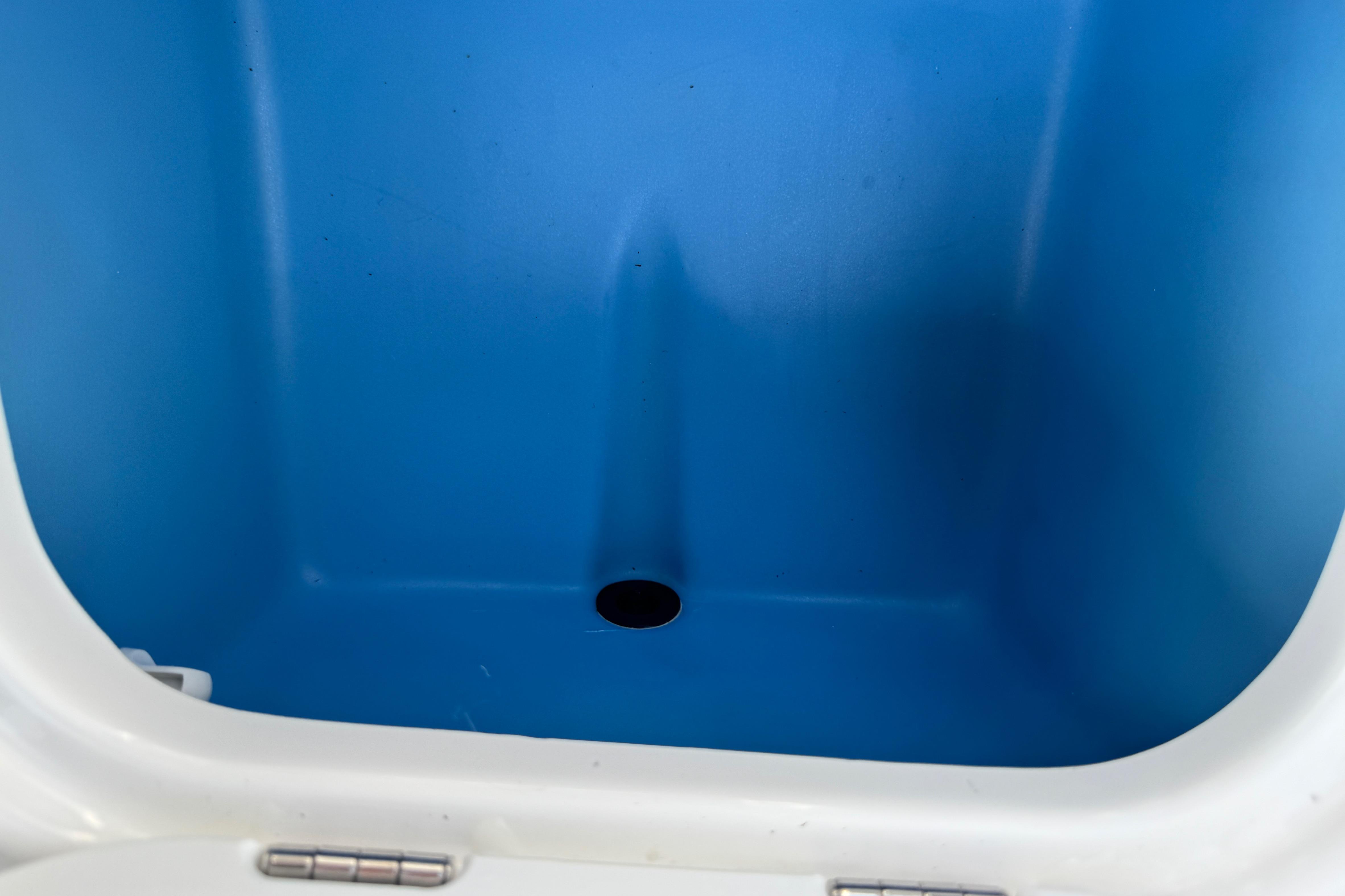 2024 Tahoe 185 S boat storage compartment with blue interior and drain hole.