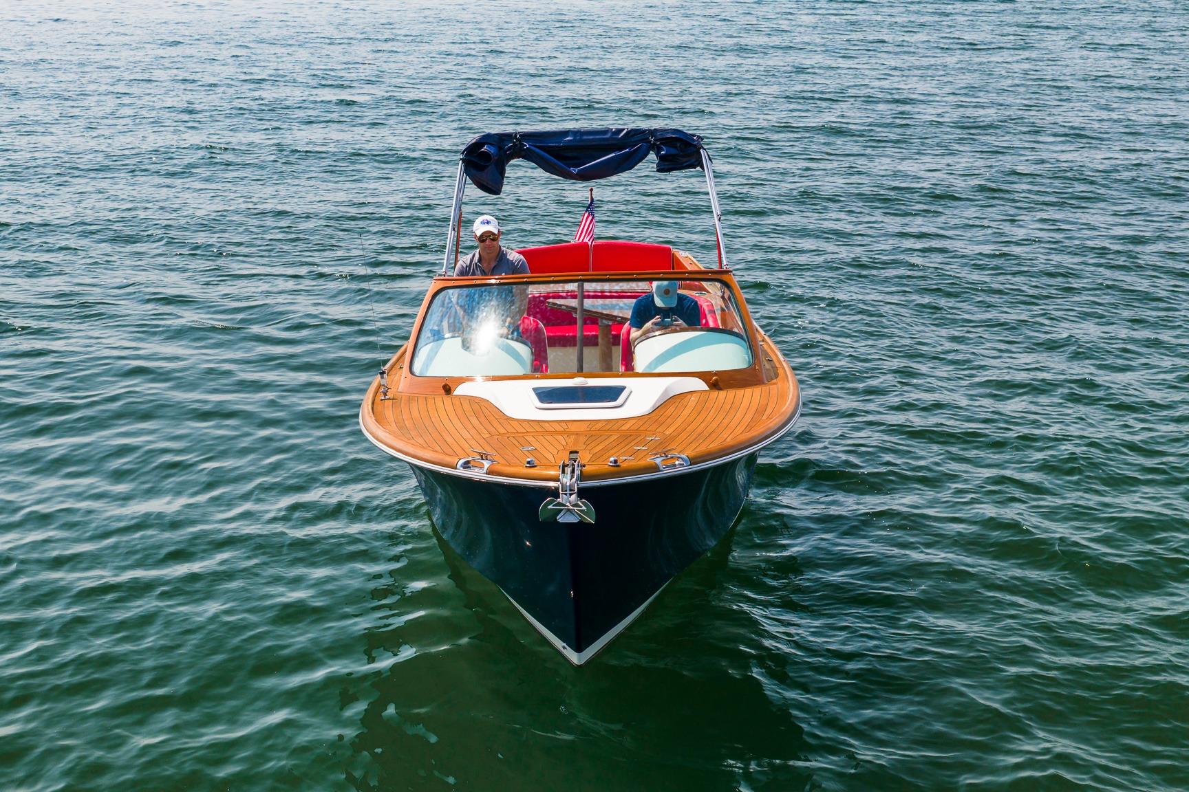 2005 Hinckley Talaria 29R boat on open water, featuring wooden deck and American flag.