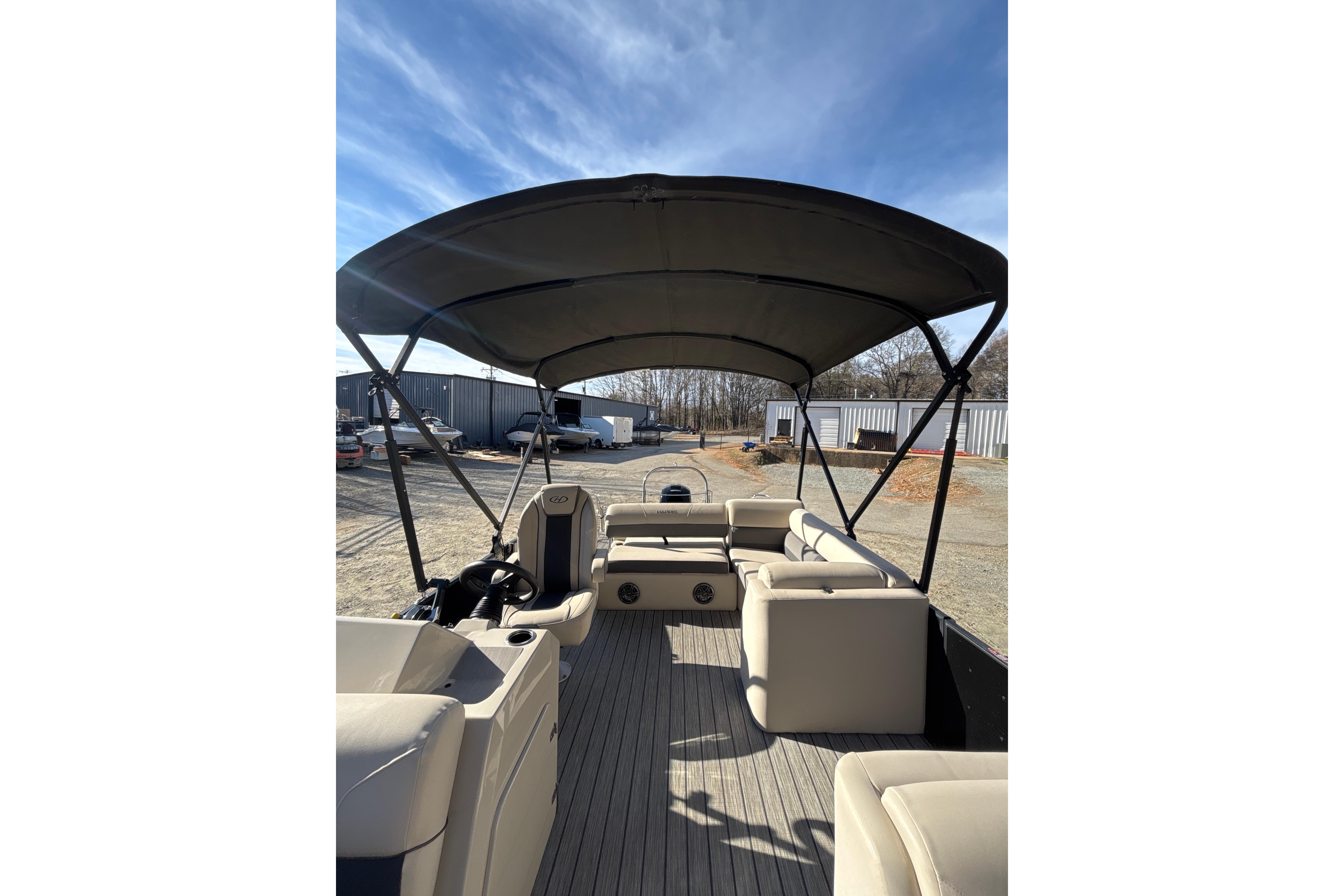 2023 Harris Cruiser 230 pontoon boat interior with canopy, showcasing seating and helm.