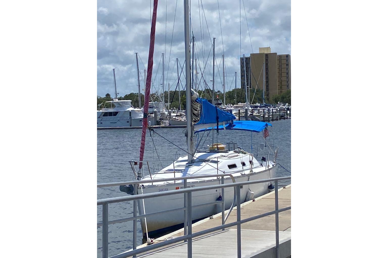 2006 Beneteau Oceanis Clipper 323 sailboat docked at marina under cloudy sky.